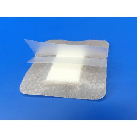 Quadratischer Verband mit transparenten Klebestreifen. Der Verband hat eine helle, rechteckige Mitte und eine strukturierte, transparente Umrandung.
