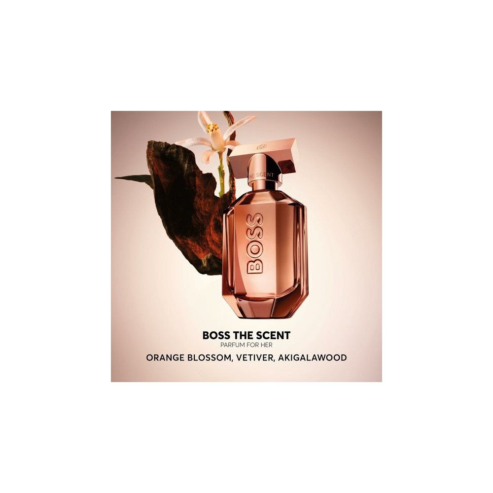 Parfümflakon mit floralen Elementen. Rosafarbener Flakon mit goldfarbenem Verschluss. Text: BOSS THE SCENT PARFUM FOR HER.