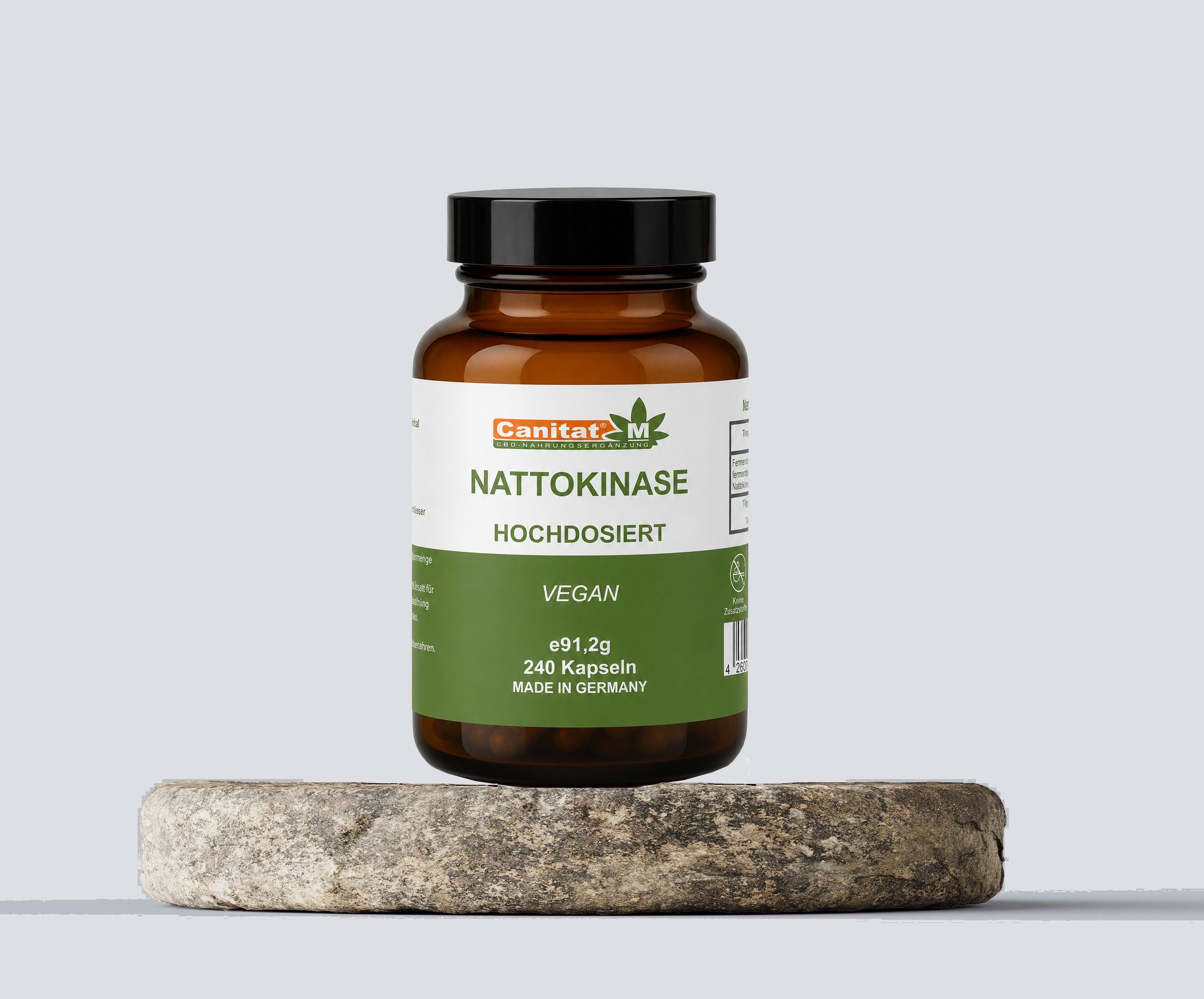 Braune Glasflasche mit schwarzen Deckel. Auf Stein platziert. Etikett mit Produktnamen Nattokinase, vegan, 240 Kapseln. Marke Canitat M.