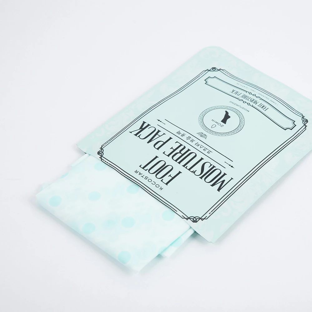 Hellblaues Paket mit Fußmaske. Text: KOCOSTAR FOOT MOISTURE PACK. Gepunktete Maske liegt heraus. Weißer Hintergrund.