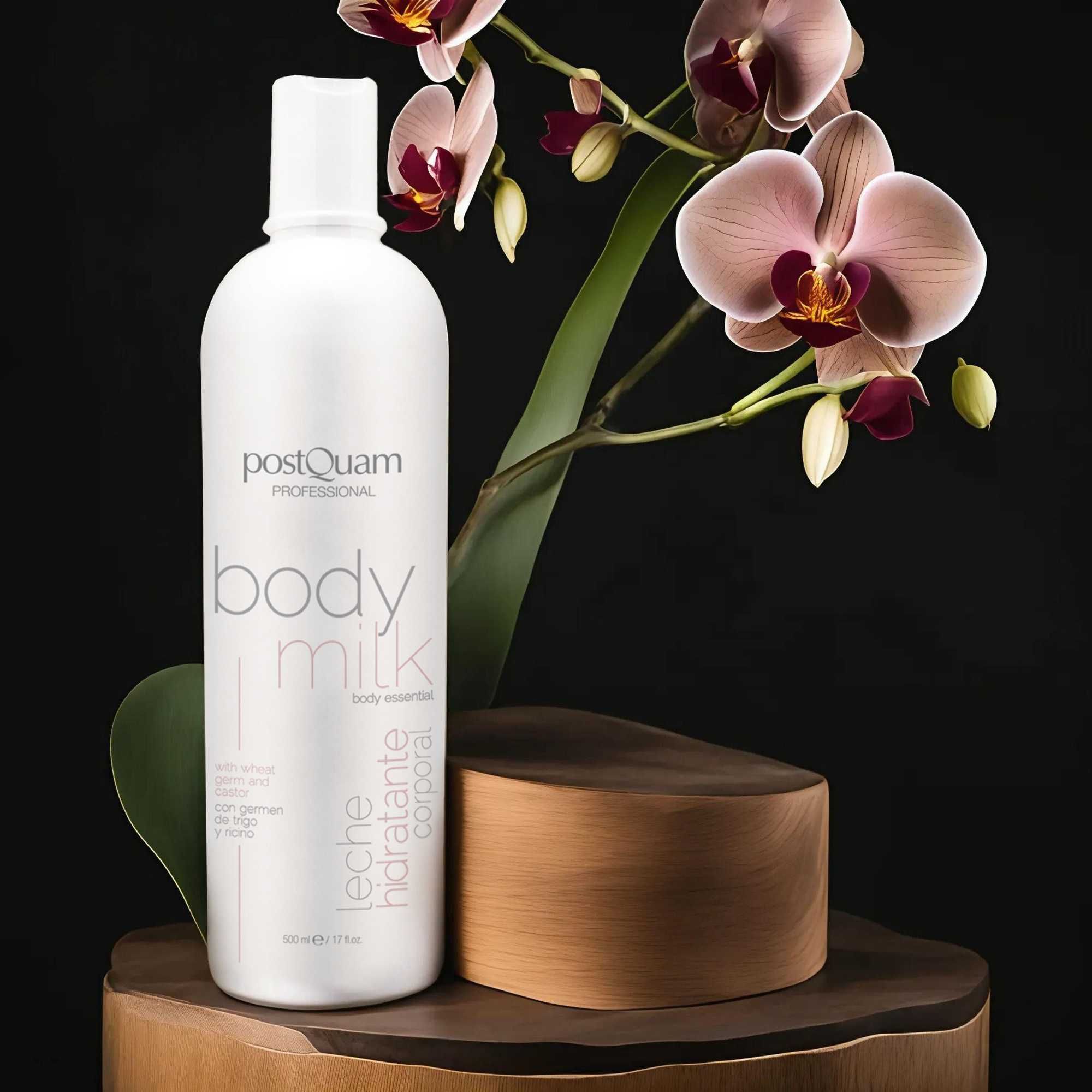 Weiße Flasche "Postquam Professional Body Milk" vor Orchideen und Holzsockel.
