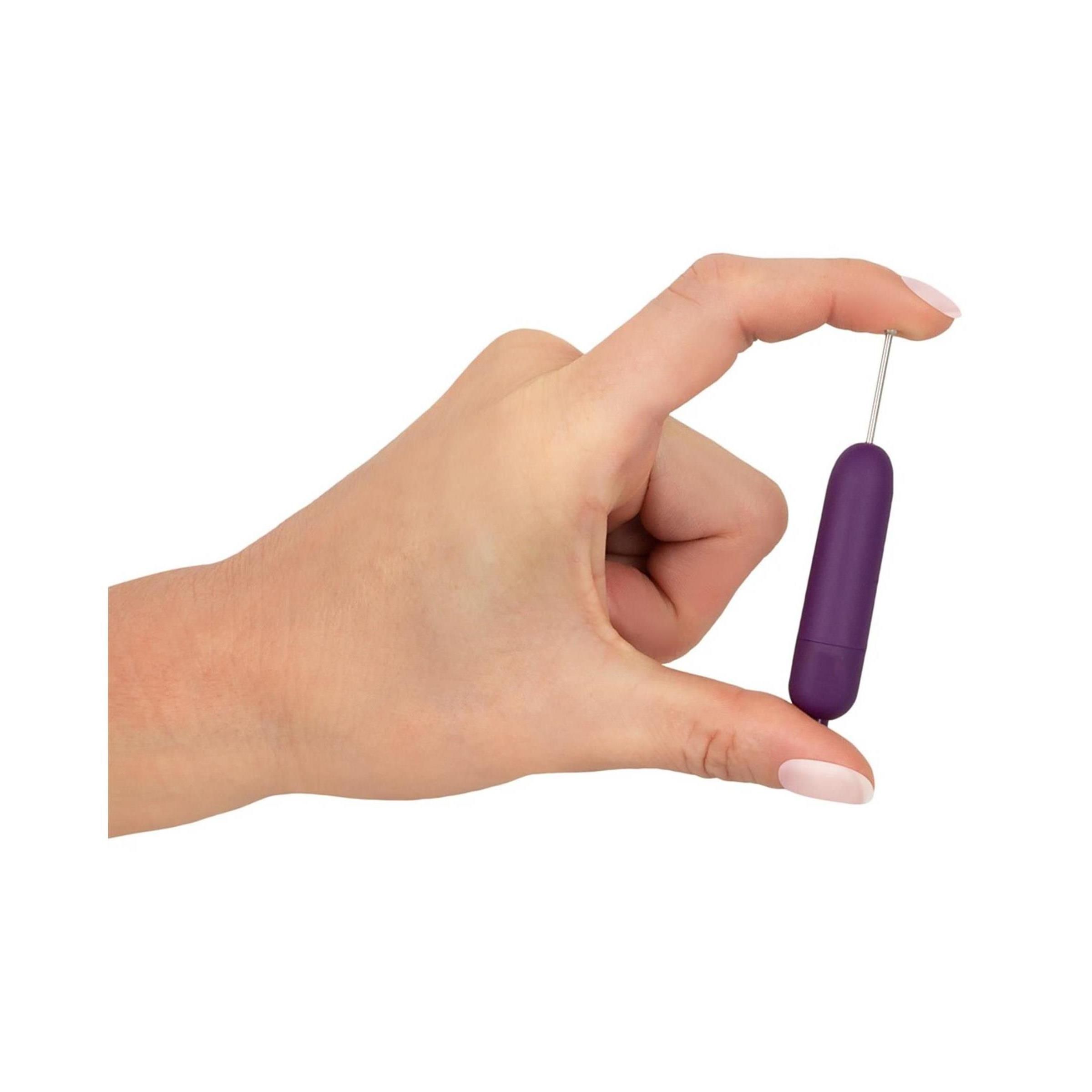 Hand hält lila Vibrator mit silbernem Stab und Kugel. Zylindrische Form.