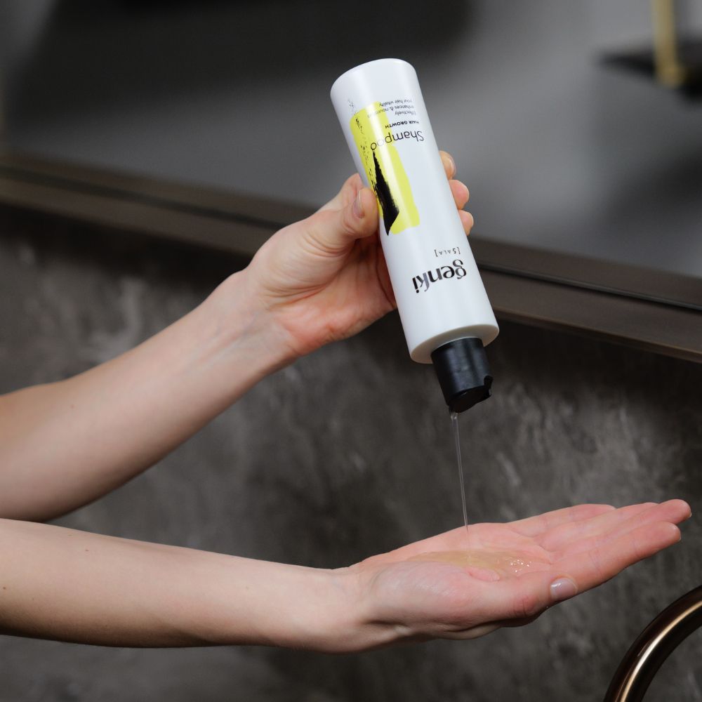 Person gießt Genki Shampoo in die Hand. Weiße Flasche mit schwarzem Deckel. Gelber Akzent. Schriftzug: Genki, Shampoo.