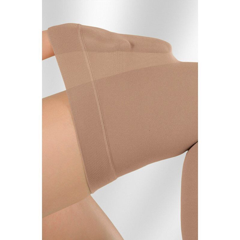 Nahaufnahme einer beigefarbenen Kompressionsstrumpfhose. Der obere Teil des Beins ist zu sehen.