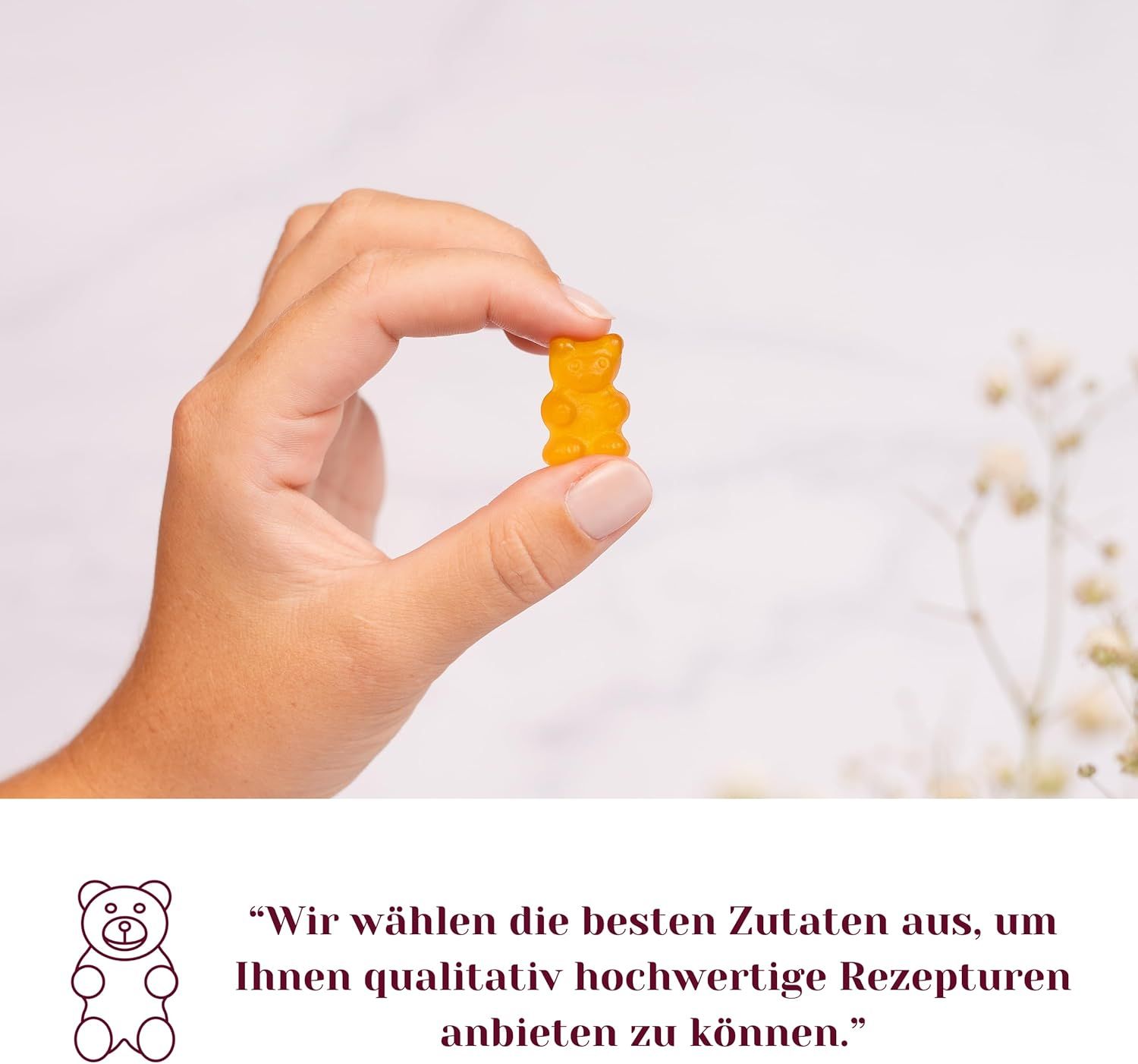 Hand hält ein einzelnes gelbes Gummibärchen. Text über die Auswahl der besten Zutaten.
