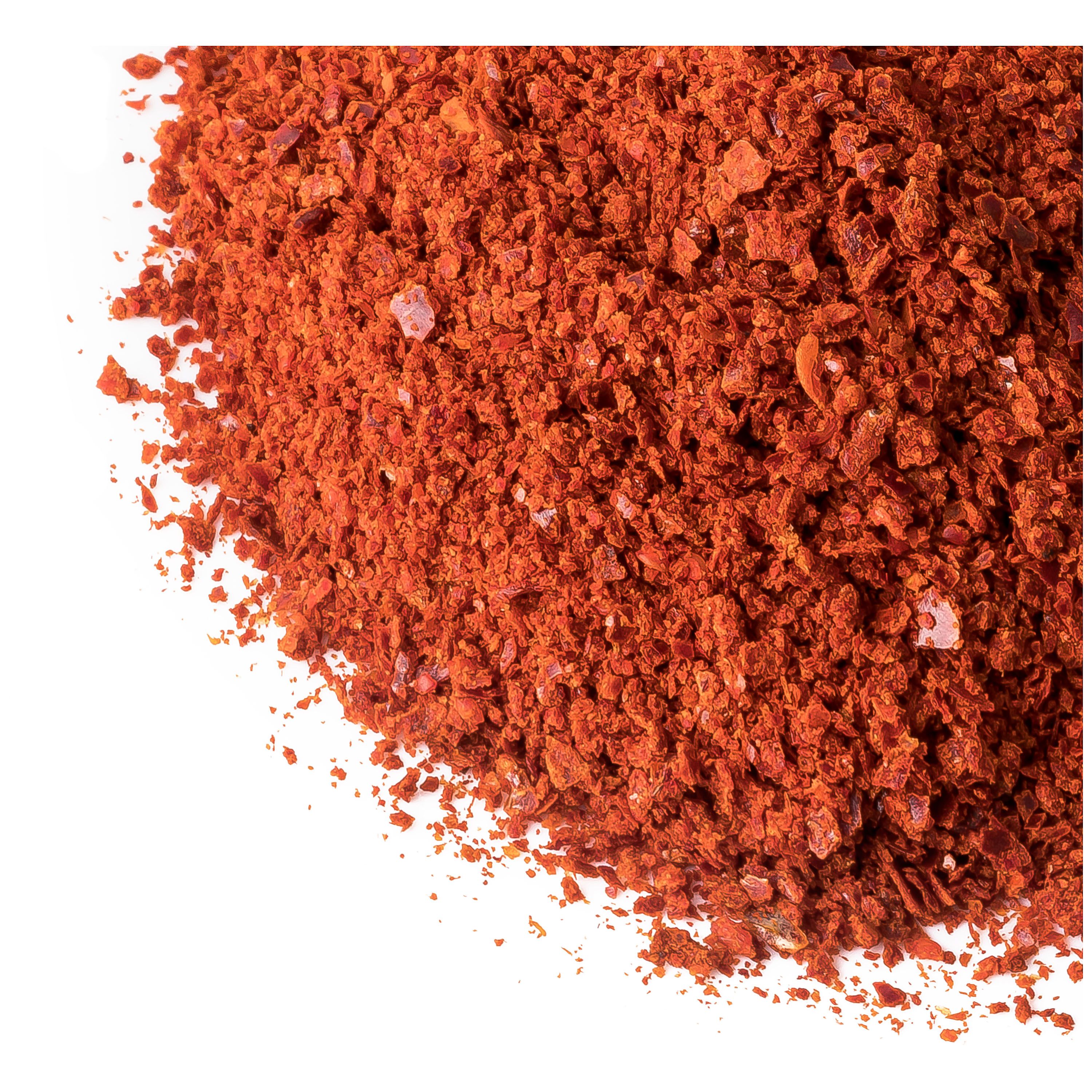 Haufen rotes Chilipulver mit sichtbaren Flocken und Kristallen. Auf weißem Hintergrund.
