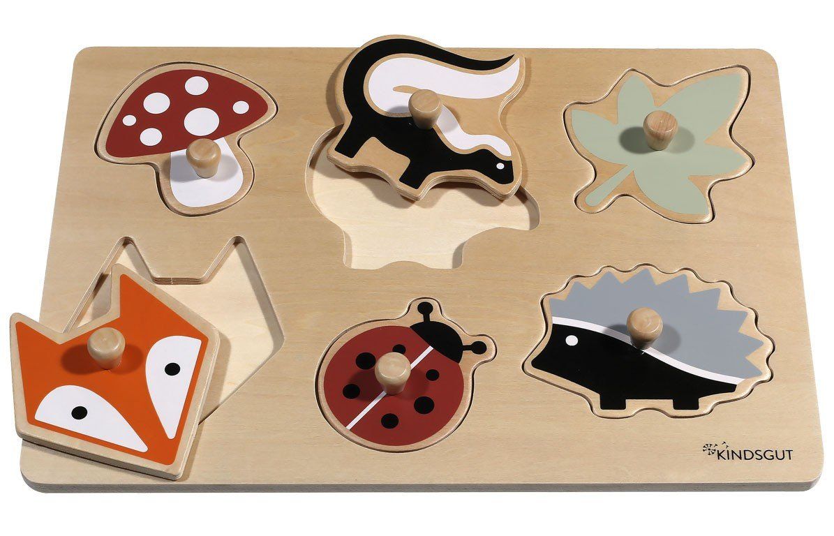 Holzpuzzle mit Waldtieren. Sechs farbige Puzzleteile: Pilz, Stinktier, Blatt, Fuchs, Marienkäfer, Igel. Puzzleteil Fuchs fehlt.