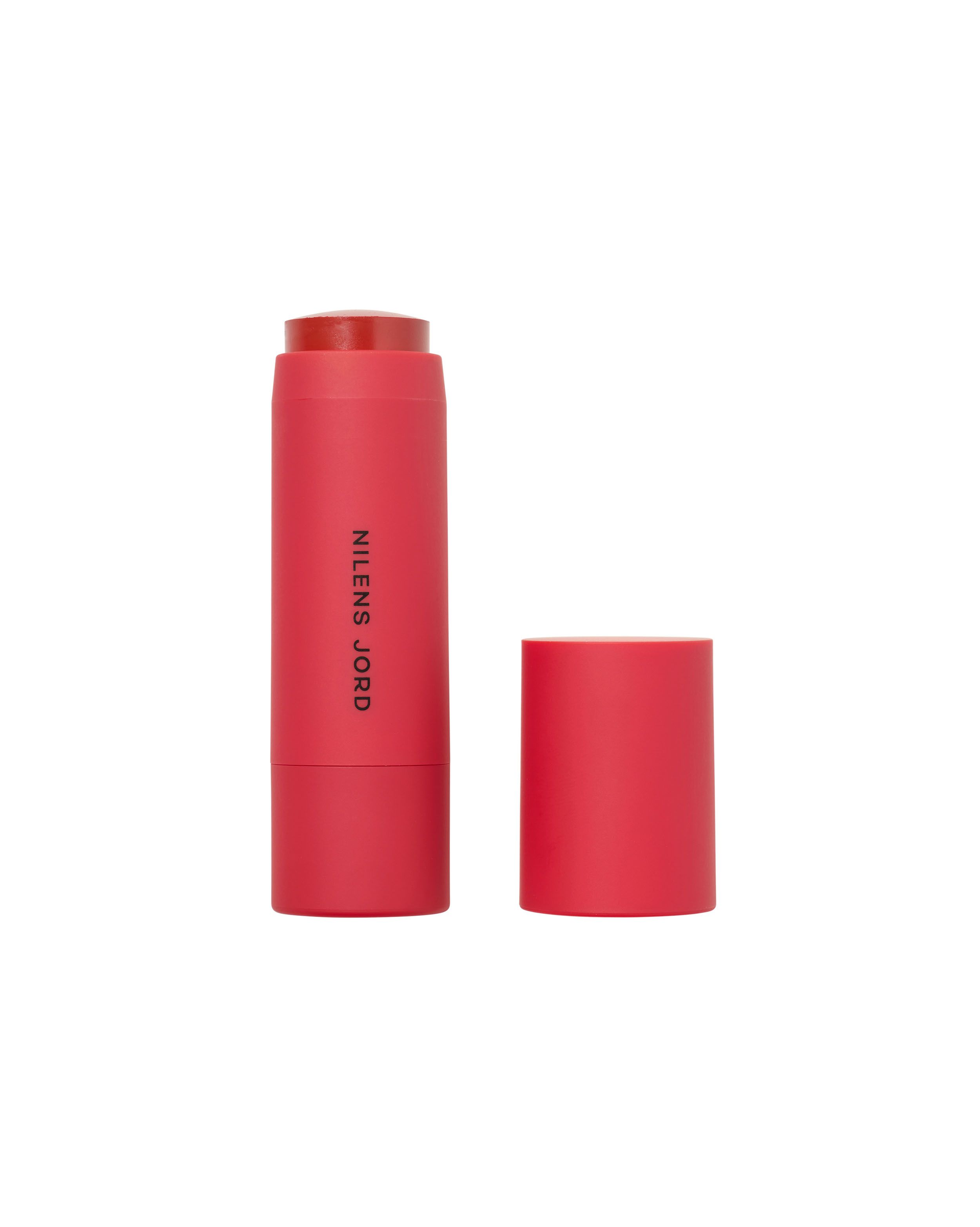 Roter Lippen- und Wangen-Stick von Nilens Jord, Kappe daneben.