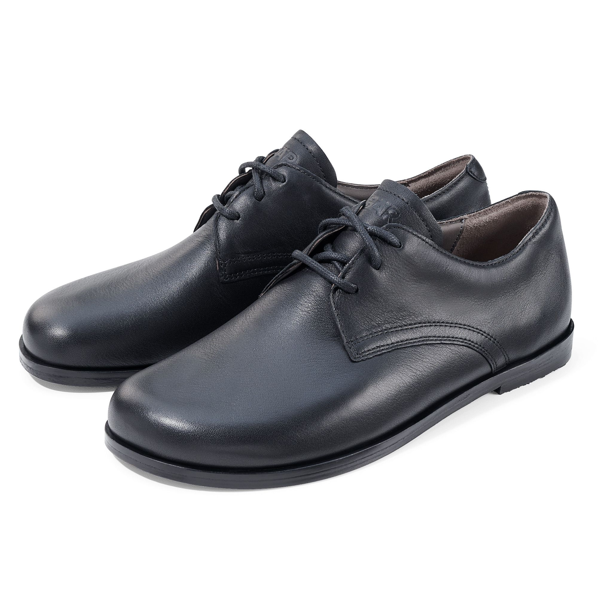 Zwei schwarze Lederschnürschuhe. Breite Passform. Schnürsenkel. Schwarze Sohle.