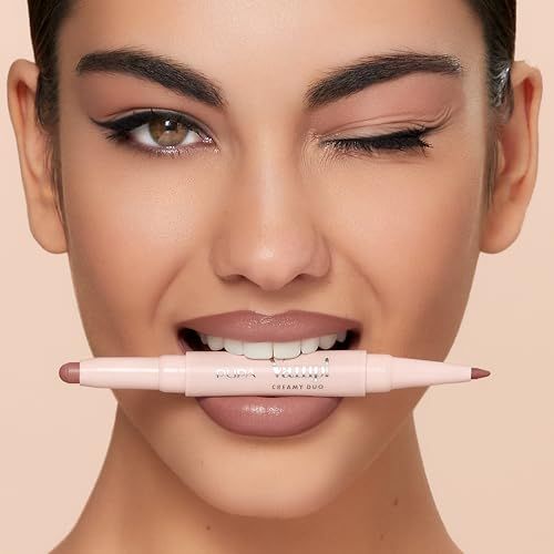 Frau hält einen doppelten Lippenstift in hellem Rosa in ihrem Mund, der Lipliner und Lippenstift kombiniert.