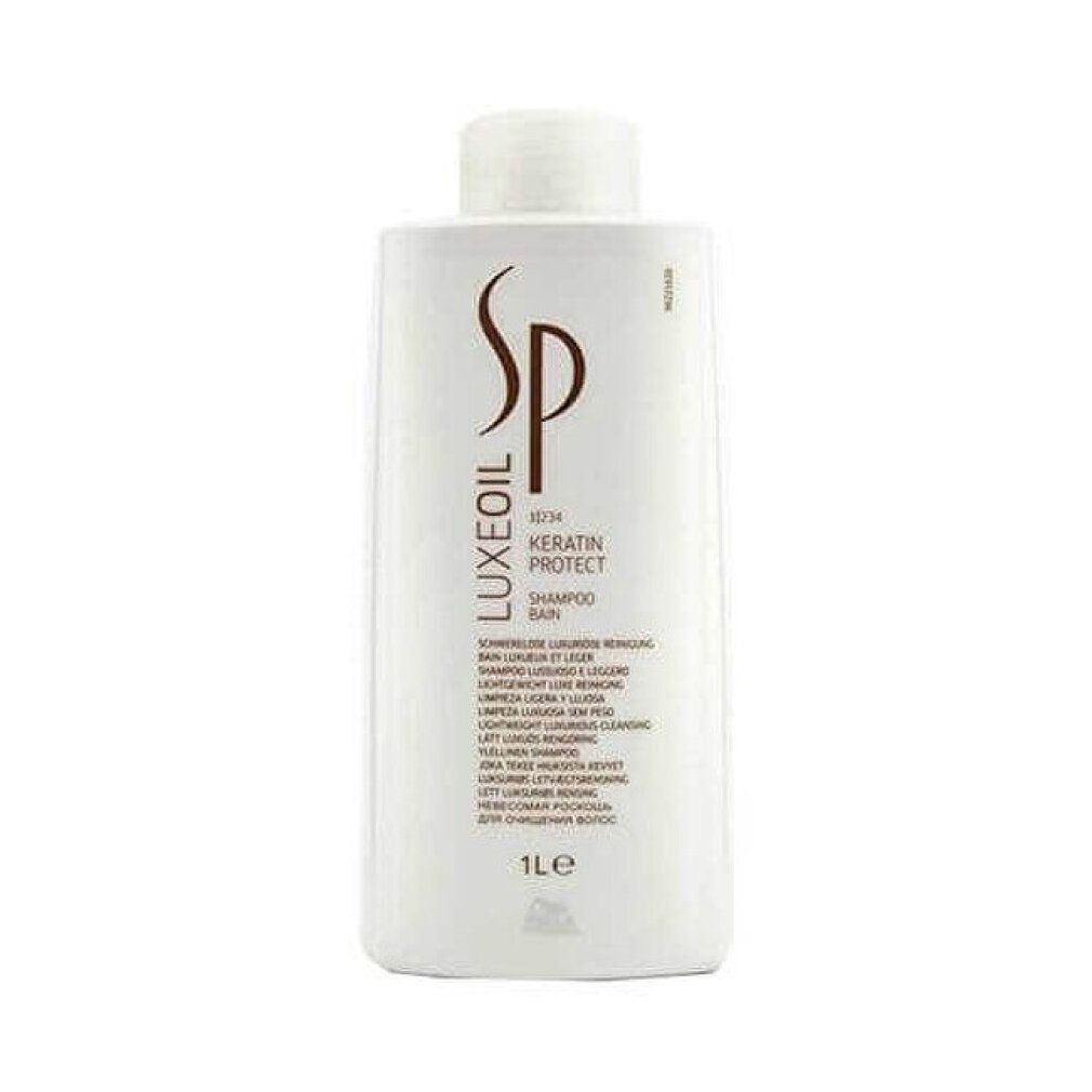 Rechteckige weiße Shampoo-Flasche mit braunem Logo und Text. Enthält "LUXEOIL", "KERATIN PROTECT SHAMPOO". Volumen: 1L. Marke: Wella.