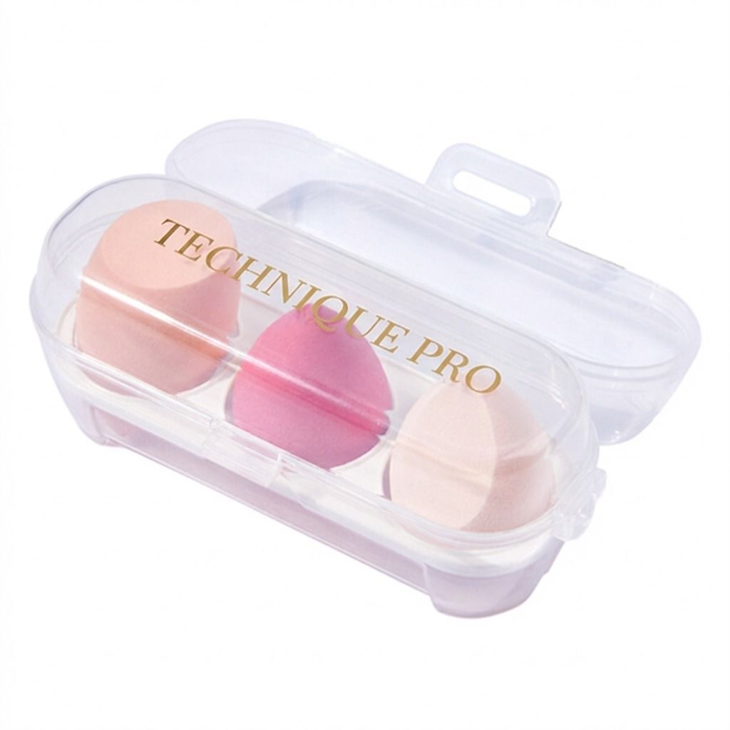 Drei Make-up-Schwämme in Rosa und Pfirsichtönen in einem durchsichtigen Reiseetui mit der Aufschrift "TECHNIQUE PRO".