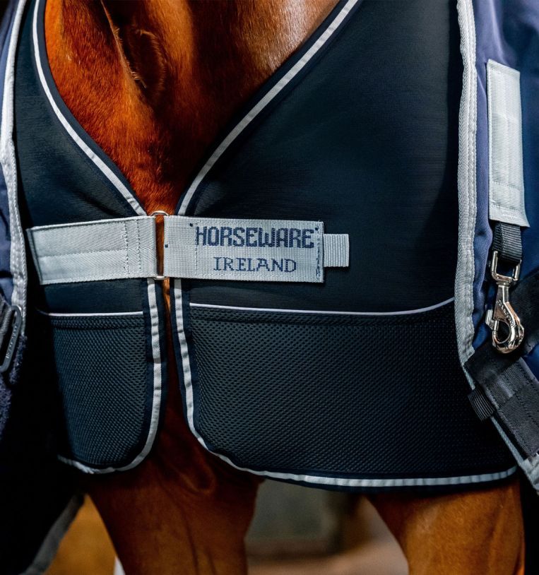 Nahaufnahme der Pferdedecke. Schwarzes Material mit weißem Rand und Logo. Marke: Horseware Ireland.