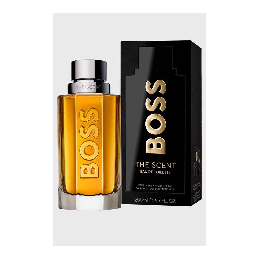 Flakon und schwarze Verpackung. Aufschrift BOSS und THE SCENT. Goldfarbene Flüssigkeit im Glas.