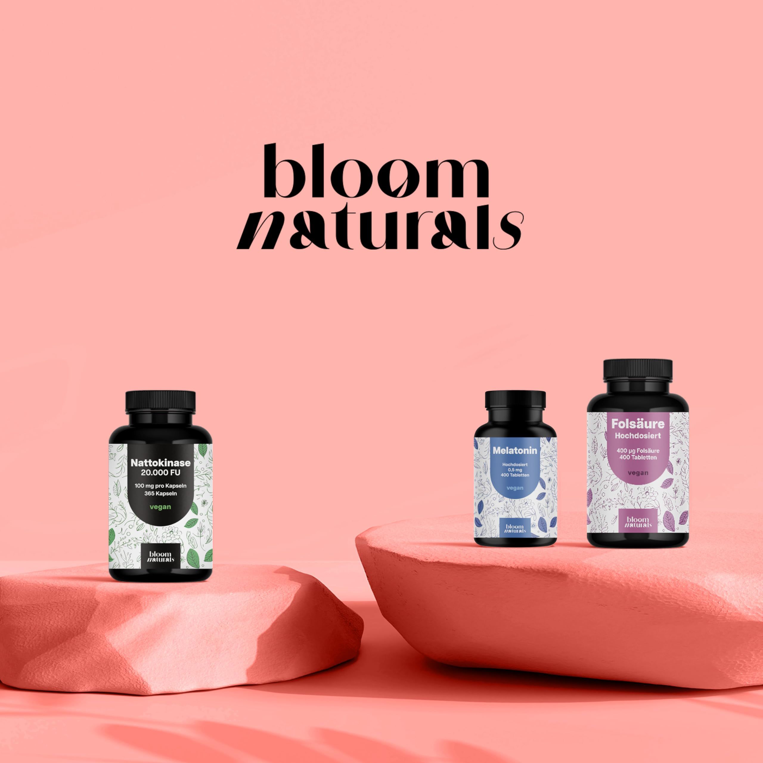 Drei Bloom Naturals Dosen auf Podesten: Nattokinase, Melatonin, Folsäure.