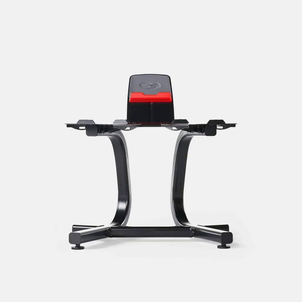 Schwarzer Hantelständer mit roter Akzentfarbe. Gebogene Stützbeine und Ablagefläche für Hanteln. Auf weißem Hintergrund.