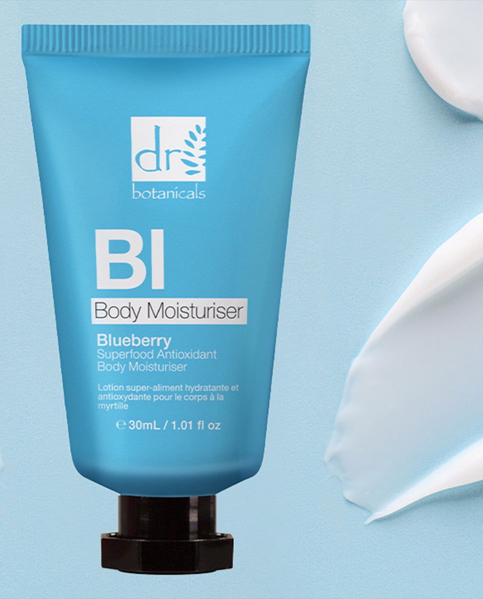 Blaue Tube mit Produktaufschrift und Creme-Klecks. Text: Blueberry Superfood Antioxidant Body Moisturiser. Logo: Dr Botanicals.