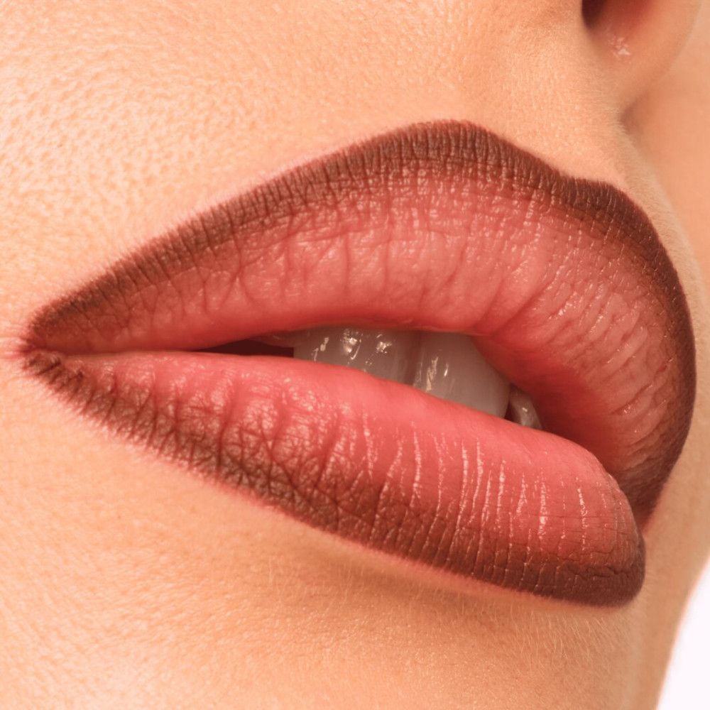 Nahaufnahme von Lippen, umrandet mit braunem Lipliner. Mund leicht geöffnet.