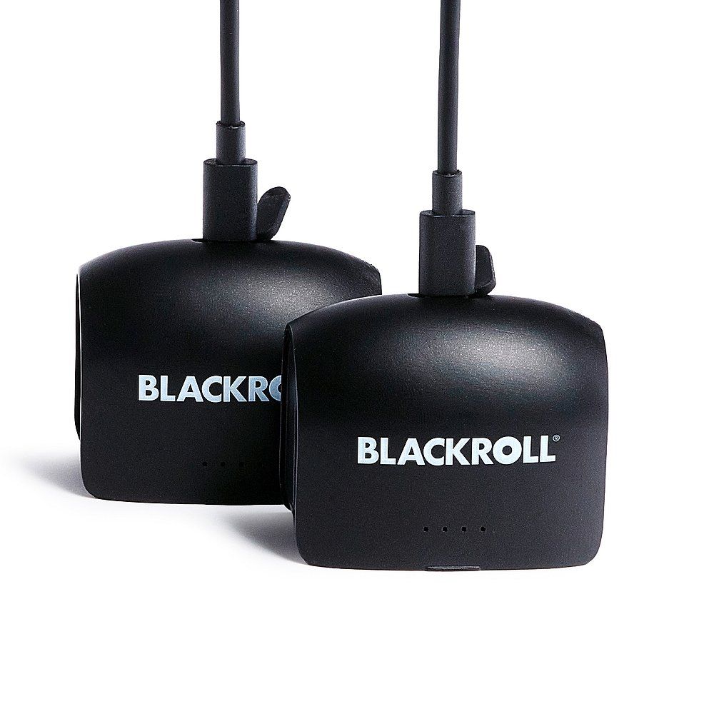 Zwei BLACKROLL Kompressionsstiefel-Module mit angeschlossenen Ladekabeln.