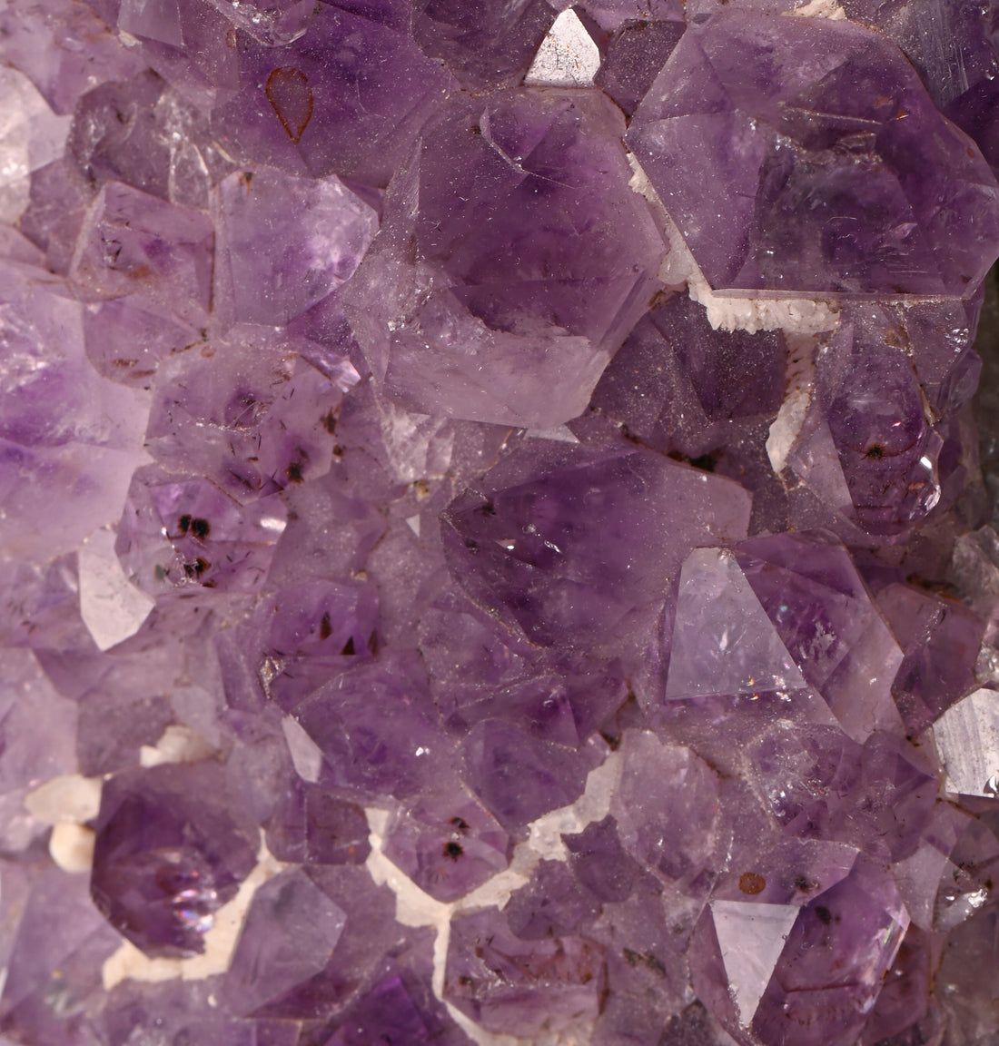 Nahaufnahme von Amethyst-Kristallen. Verschiedene Formen und Größen. Hauptsächlich lila mit weißen Einschlüssen.
