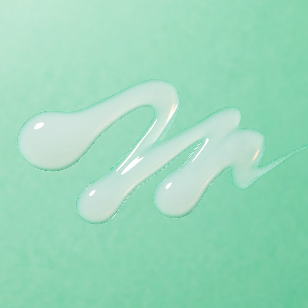 Serumtropfen auf grünem Hintergrund. Die Tropfen sind transparent und wellenförmig.
