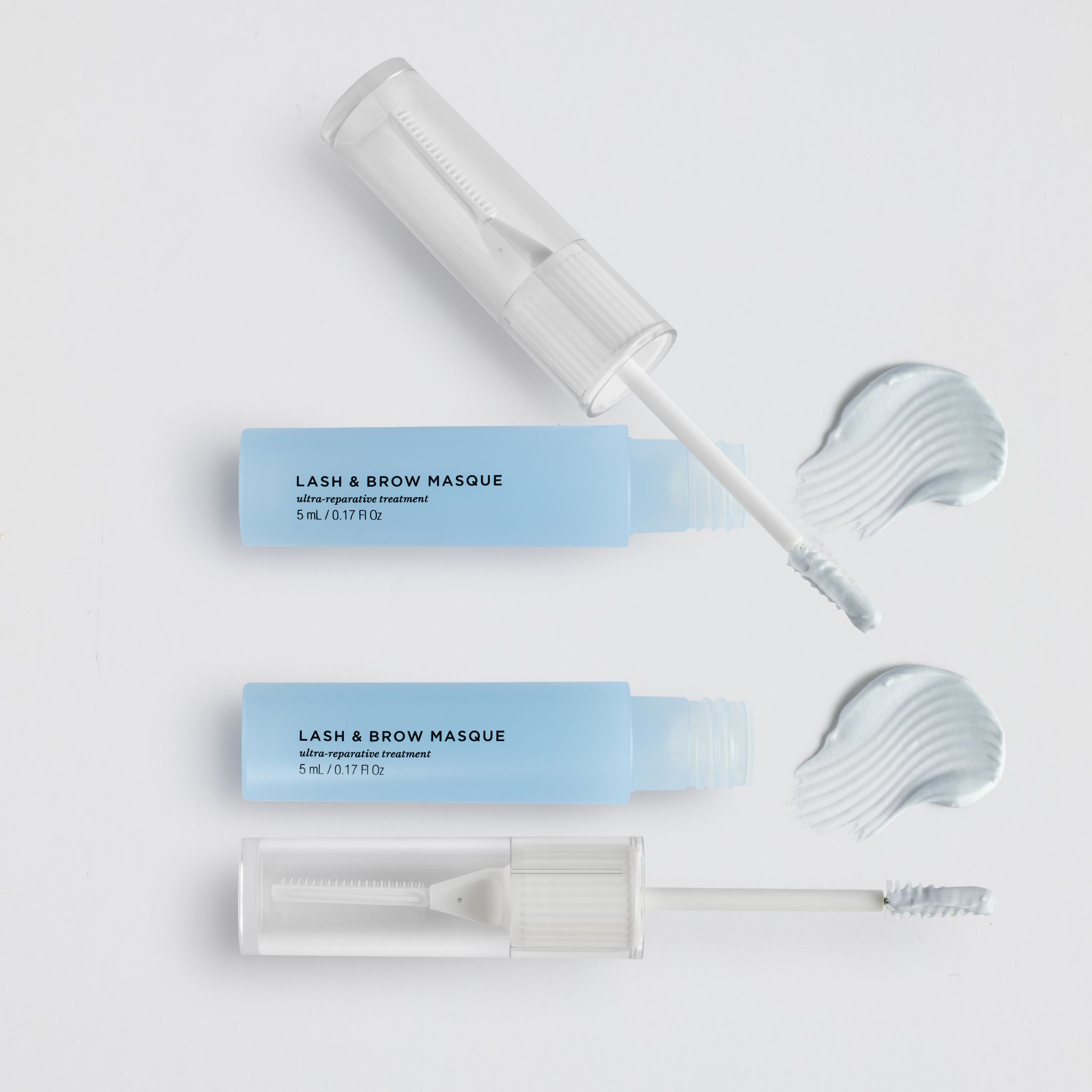 Zwei Behälter mit Wimpern- und Augenbrauenmaske und Applikatoren.