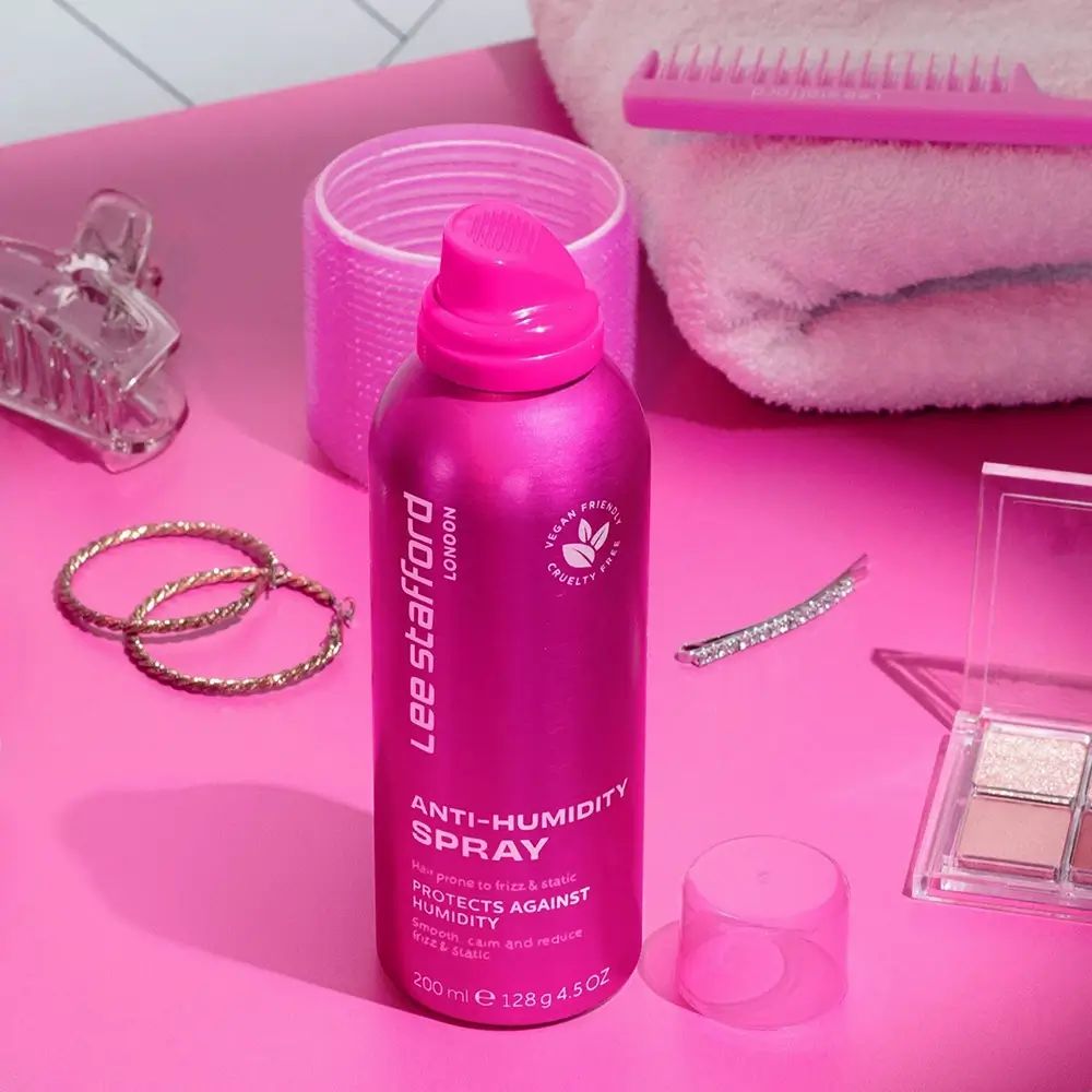 Rosa Sprühflasche 'Lee Stafford Anti-Humidity Spray' mit Zubehör. Vegan- und tierversuchsfrei-Logo. Zubehör: Haarschmuck, Schmuck, Make-up.