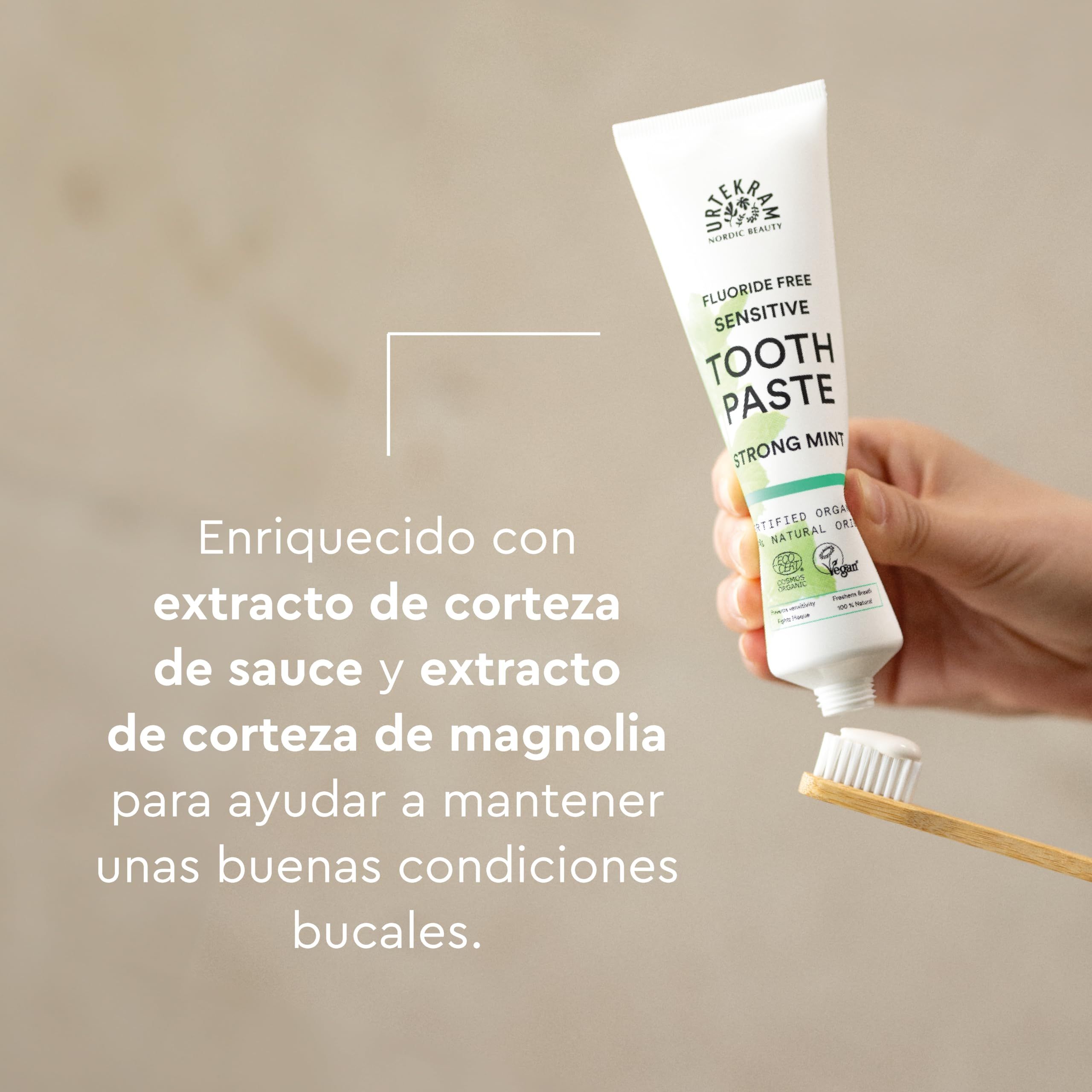 Zahnpasta-Tube, weiss mit grüner Schrift. Aufschrift: Fluoridfrei, Sensitive, Zahnpasta, Strong Mint. Zahnbürste mit Borsten.