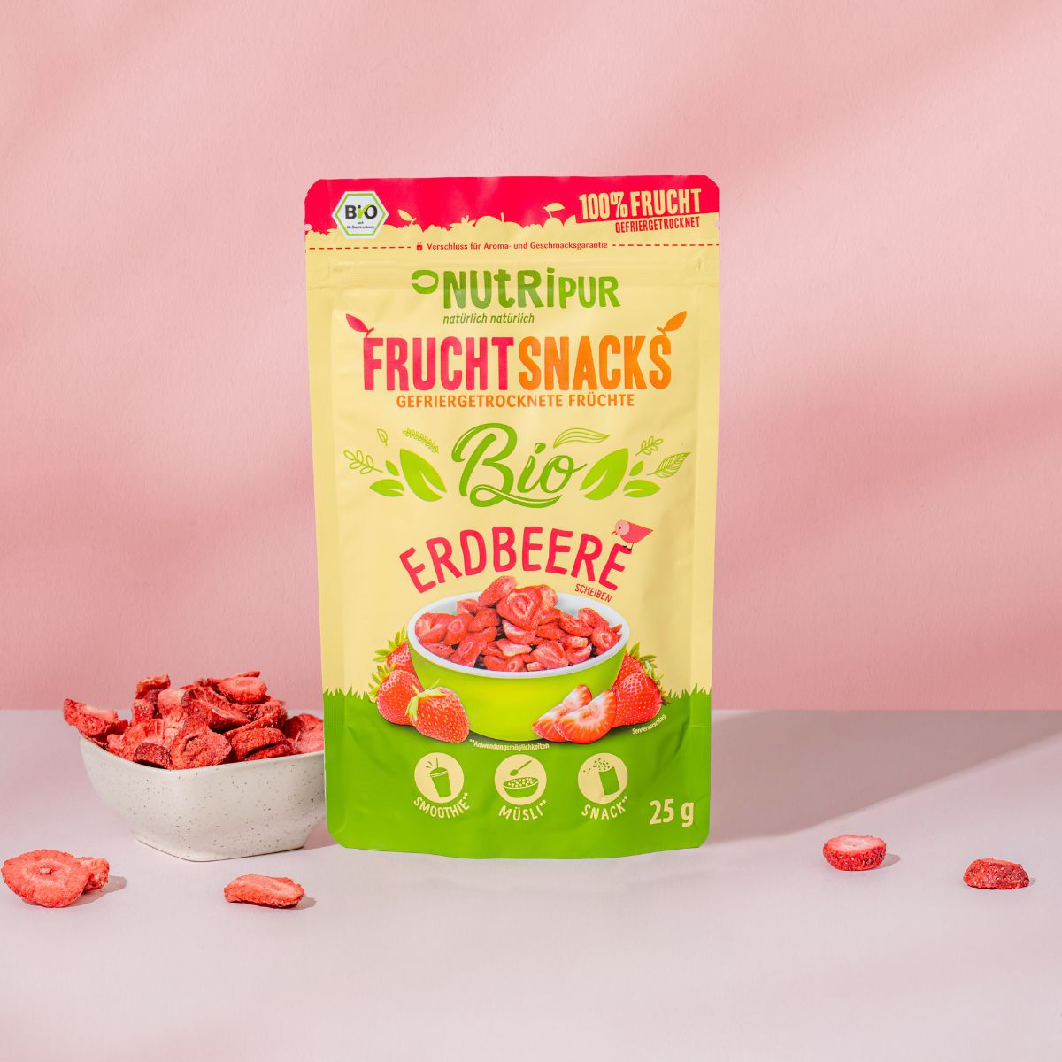 Verpackung NutriPur FruchtSnacks Bio-Erdbeere. Aufschrift: 100% Frucht, Bio, 25g. Schale mit Erdbeeren.