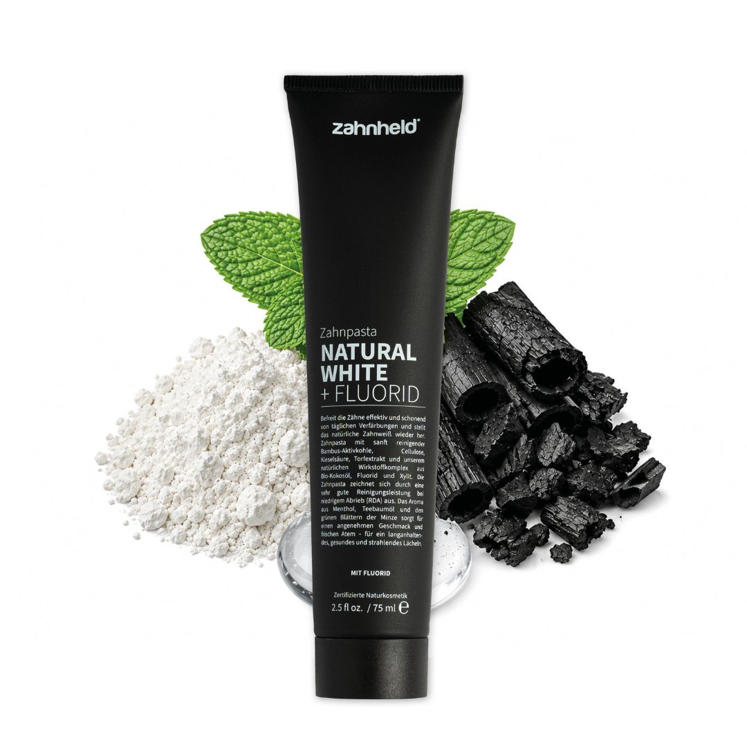 Zahnheld Zahnpasta Natural White Tube mit Aktivkohle, Fluorid, Minzblättern und weißem Pulver.
