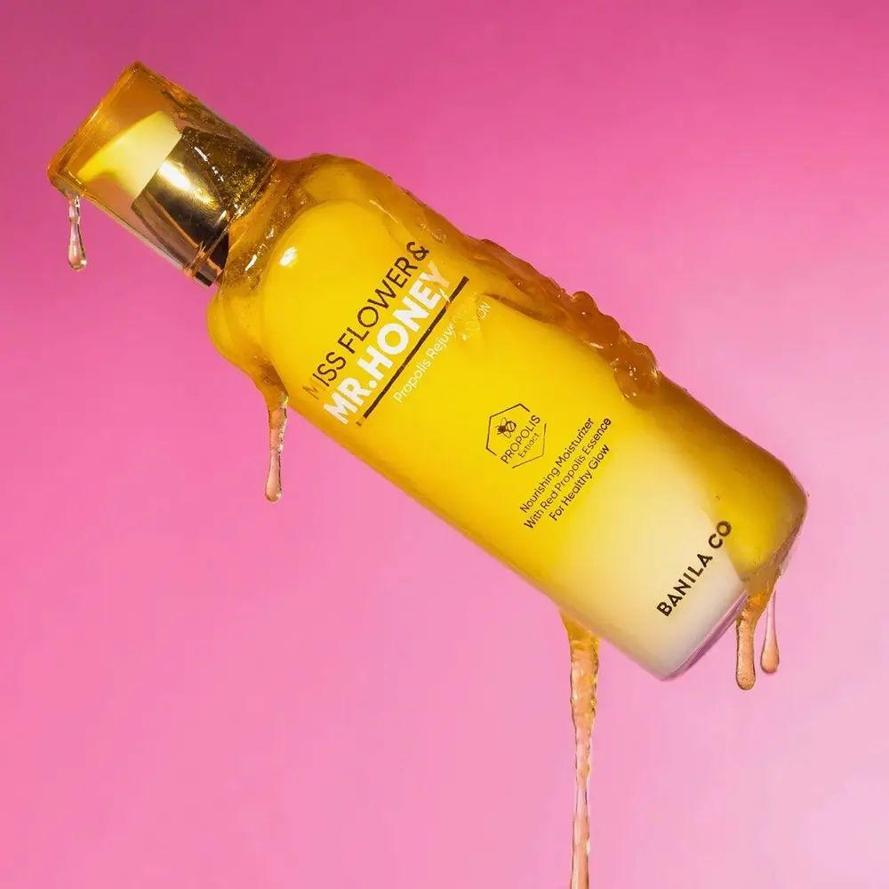 Gelb-weiße Lotionflasche mit goldfarbenem Pumpkopf, bedeckt mit Honig. Aufschrift: Miss Flower & Mr. Honey, Propolis Rejuvenating Lotion. Marke: BANILA CO.