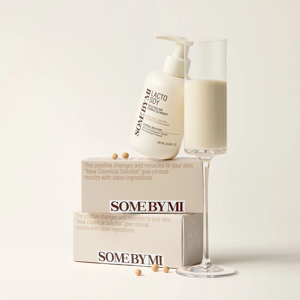 Weiße Flasche mit Pumpe, Glas mit Flüssigkeit, Verpackung. Aufschrift: SOMEBYMI Lacto Soy Mild Bubble Cleanser.