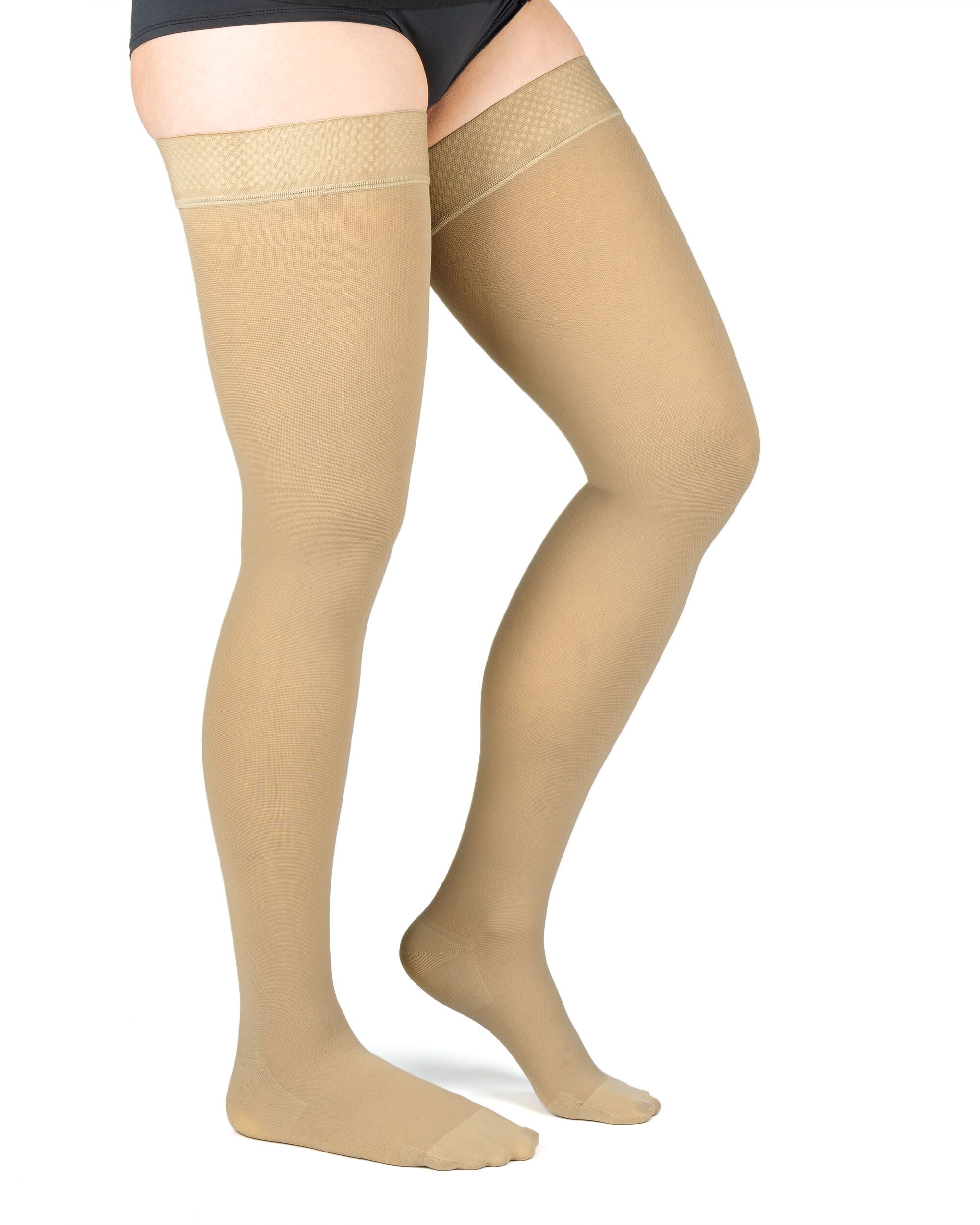 Beine einer Person mit hautfarbenen Kompressions-Schenkelstrümpfen. Strümpfe reichen bis zum Oberschenkel.