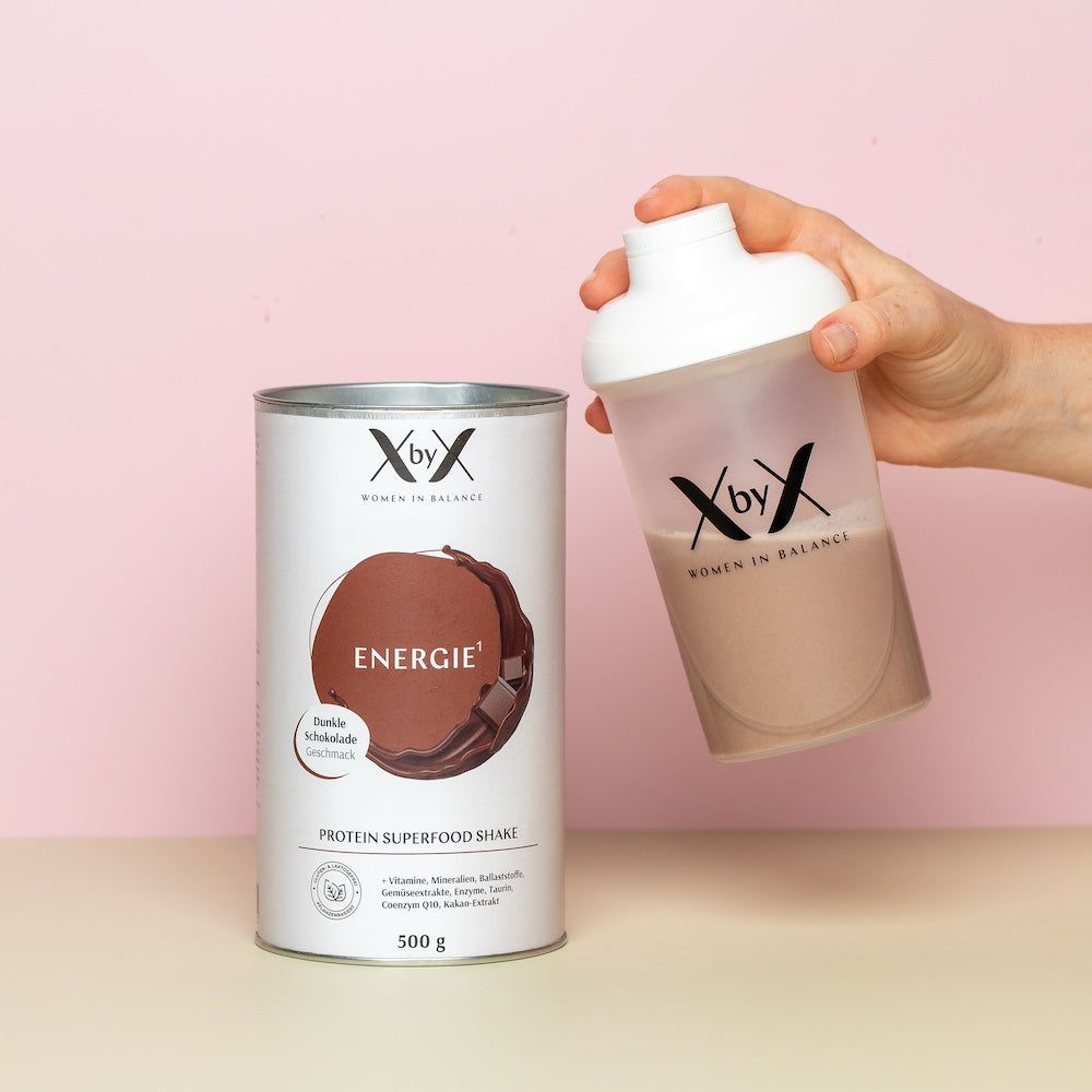 XbyX® Energie Dunkle Schokolade Dose und Shaker. Hand hält Shaker mit Shake. Produktname und Logo sichtbar. 500g.