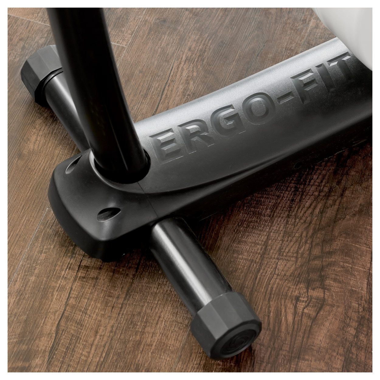 Detailansicht des Ergometer Cycle 400. Schwarze Basis mit ERGO-FIT Logo. Auf Holzfußboden.