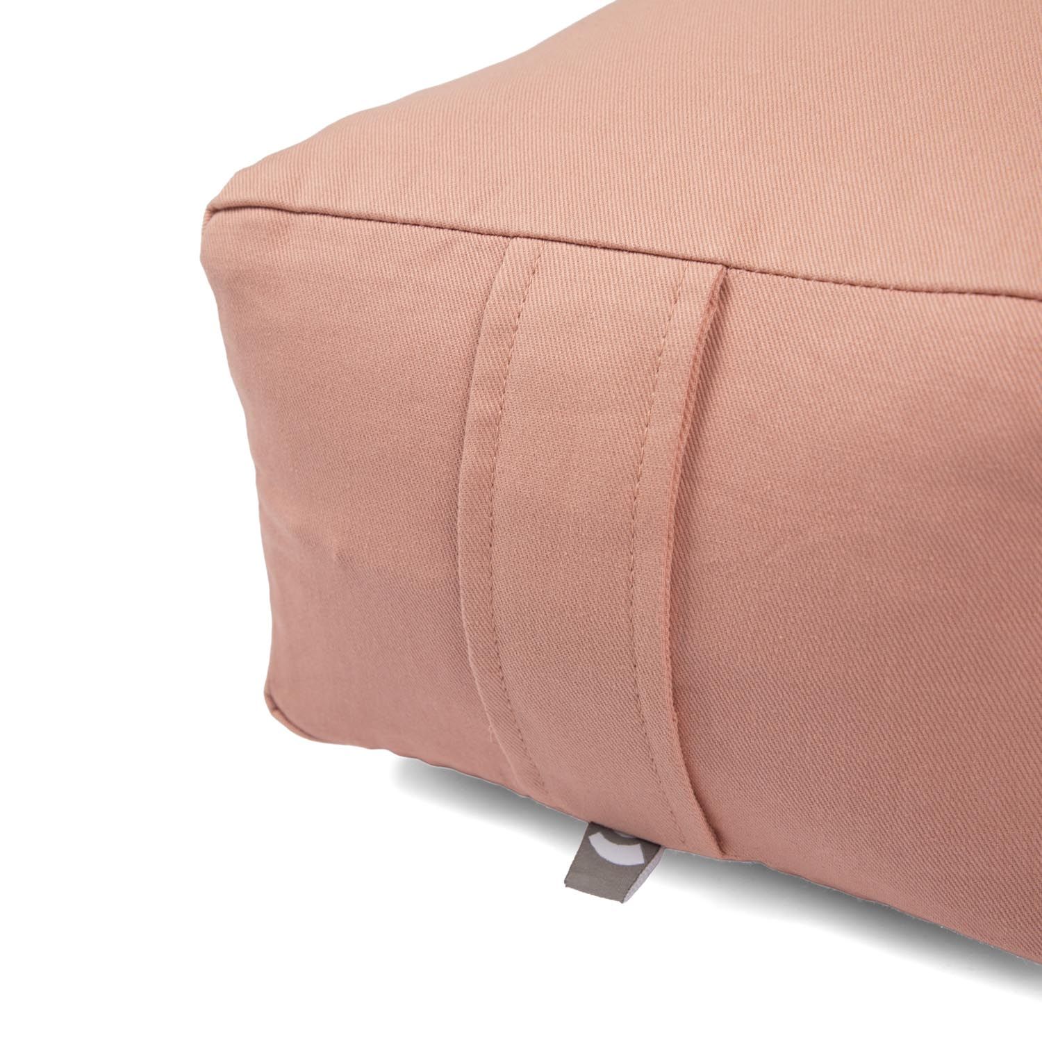 Detailansicht einer Schlaufe und eines Etiketts an der Seite eines rosa Yoga-Bolsters.