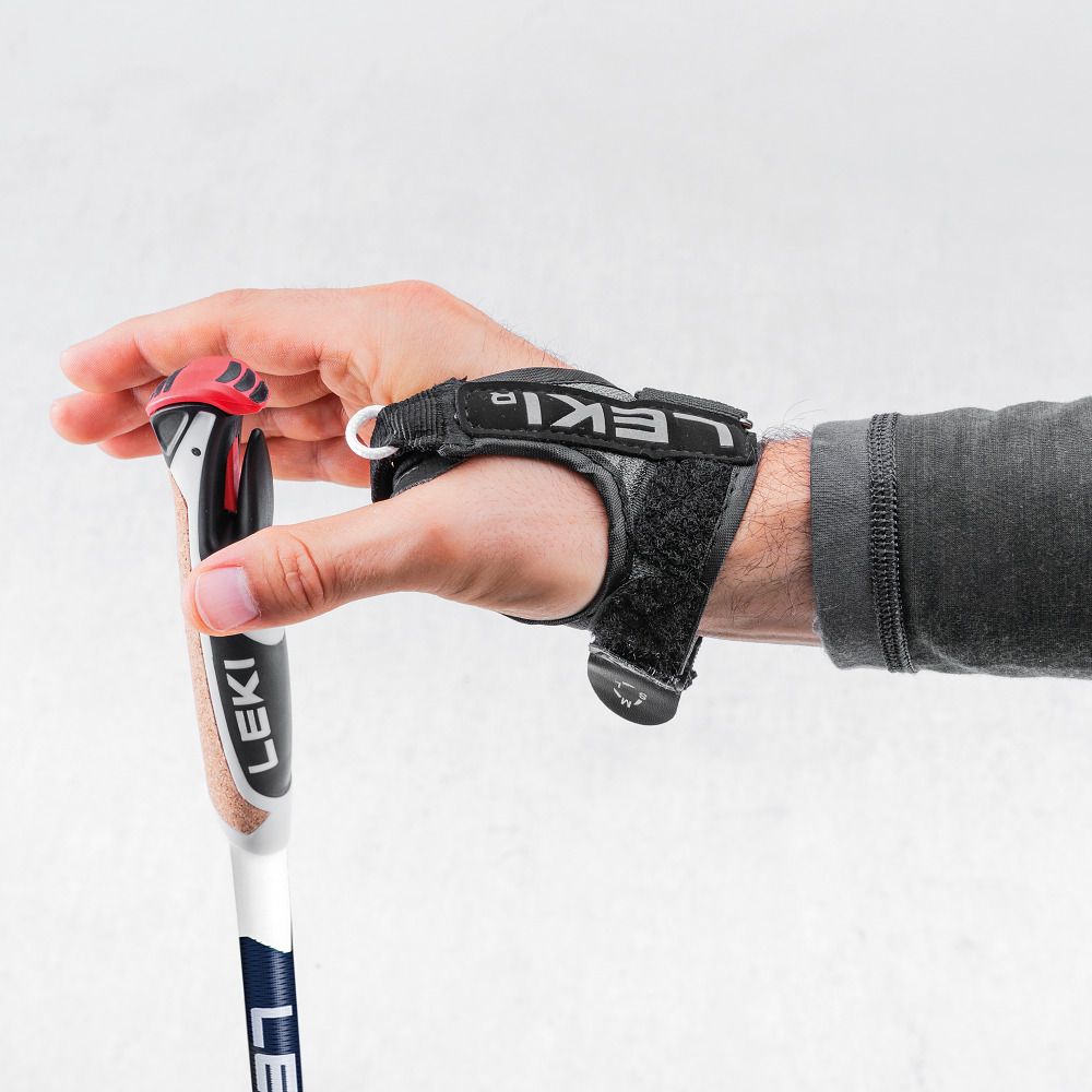 Hand mit Nordic-Walking-Stock. Schwarze Handschlaufe mit Marke Leki. Roter Akzent am Griff.