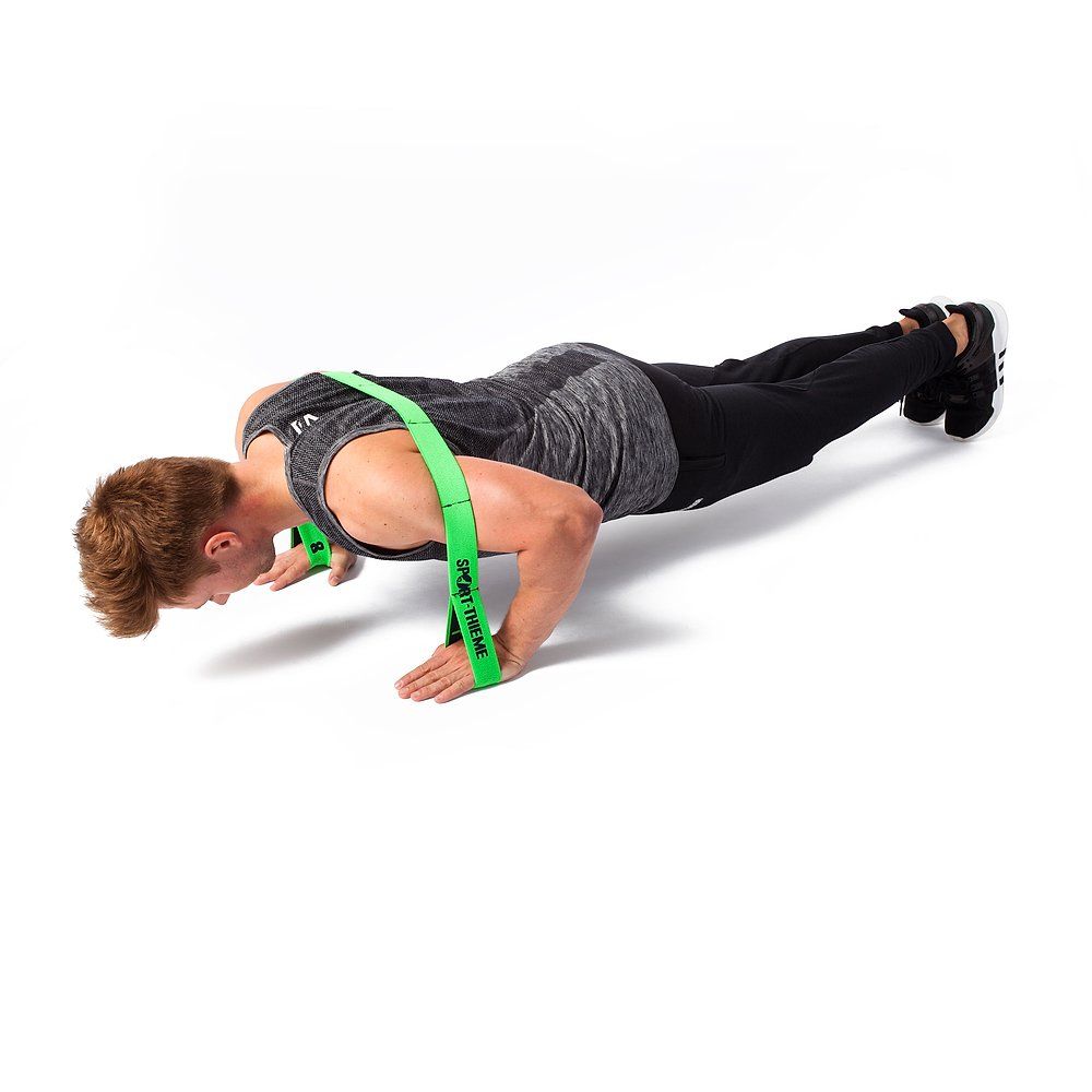 Grünes Sport-Thieme Elastikband, 8-Loop, um die Handgelenke. Eine Person macht Liegestütze auf dem Boden.