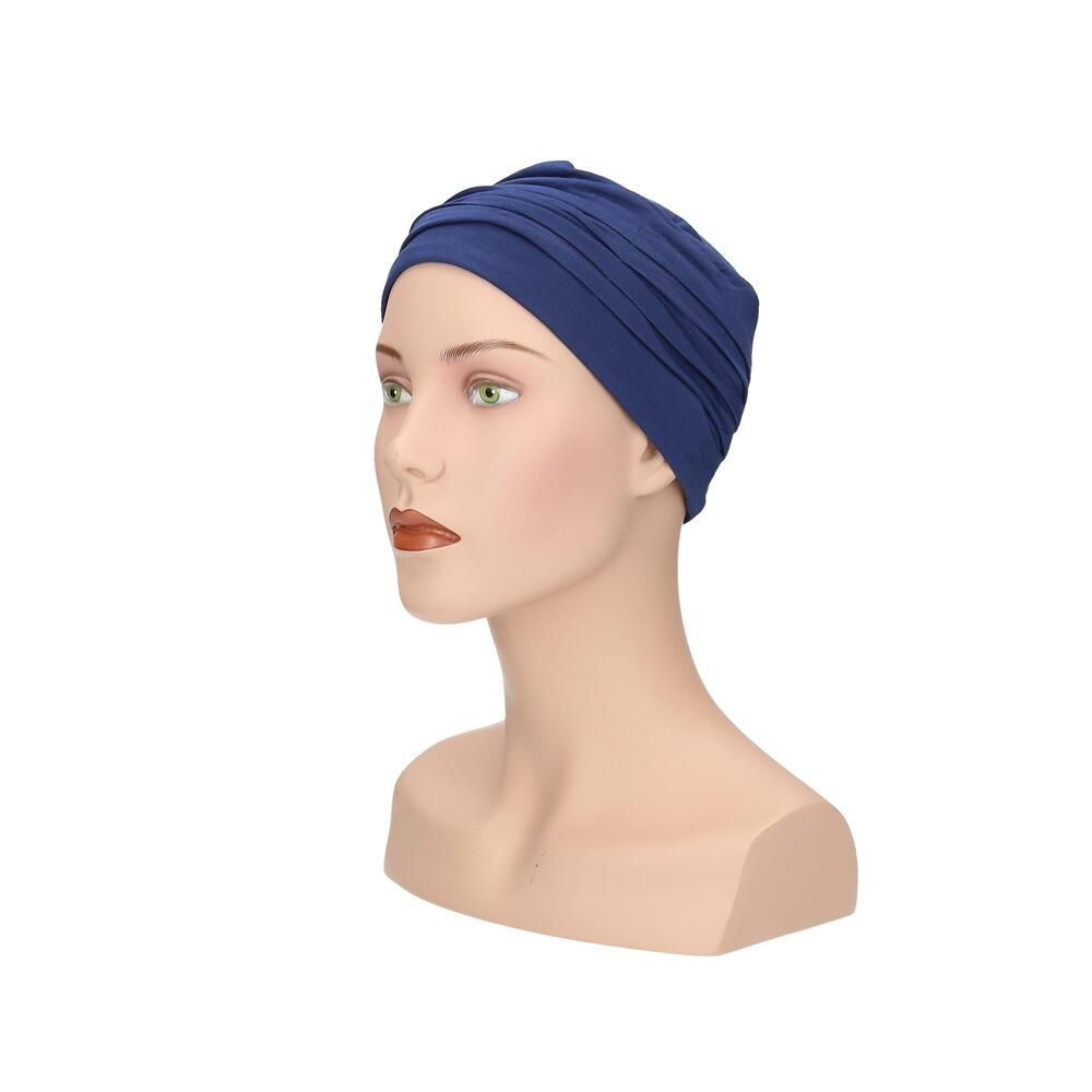 Blauer Turban auf einer Büste. Seitenansicht. Stoff mit Falten. Keine weiteren Details.