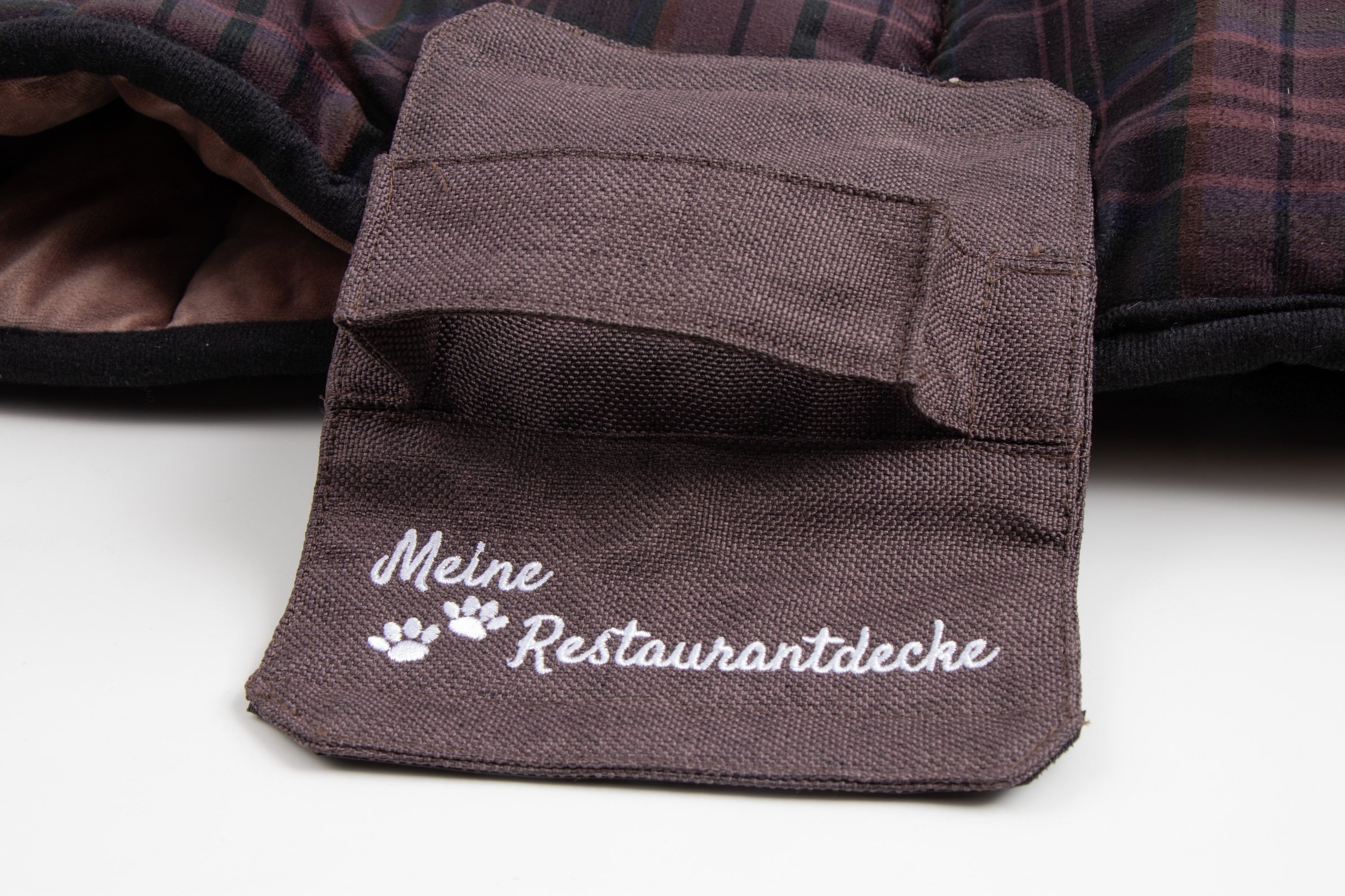 Braune Tasche mit Aufschrift "Meine Restaurantdecke" und Pfoten. Auf hellem Hintergrund.