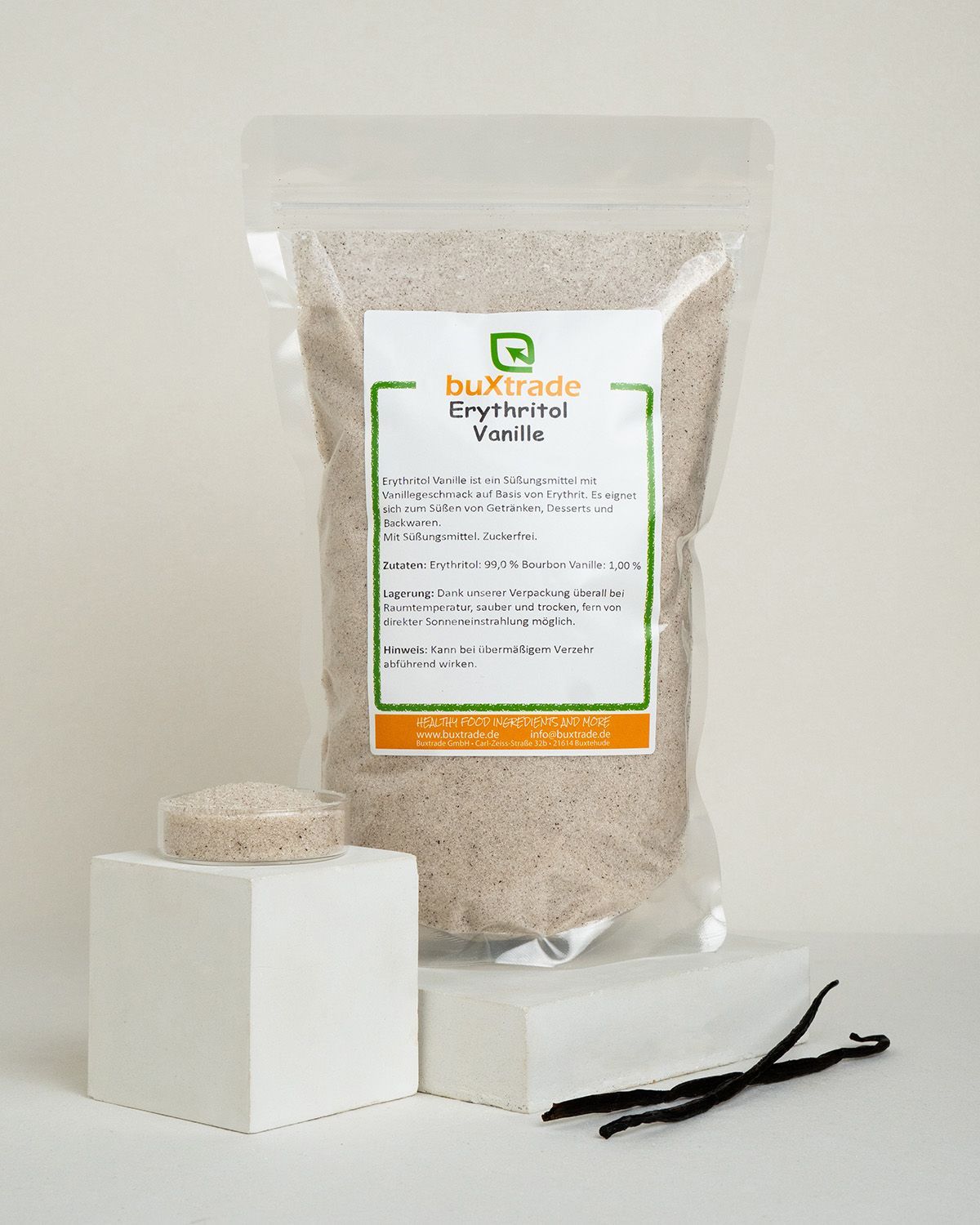 Buxtrade Erythritol Vanille in einem Beutel, daneben ein Glasbehälter mit dem Produkt und zwei Vanilleschoten.