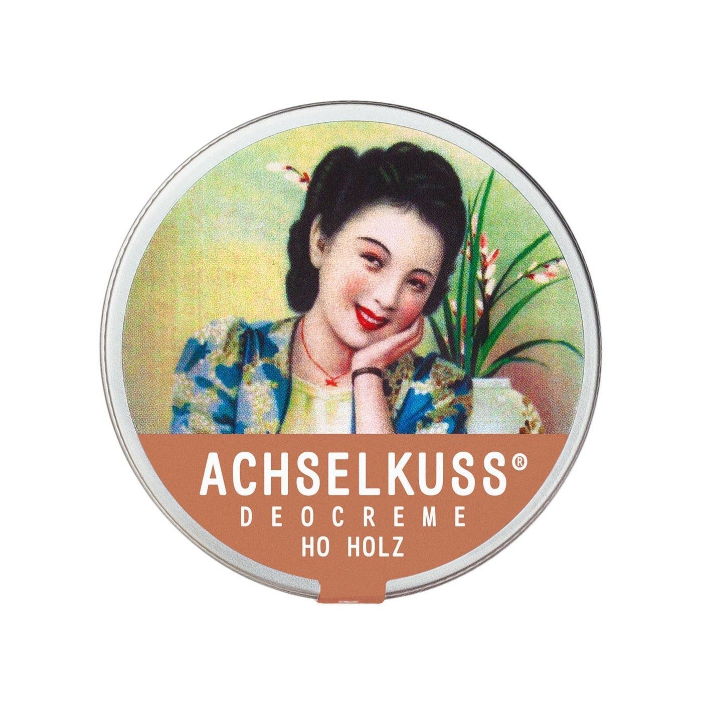 Runde Dose mit Aufdruck. Auf dem Deckel ist eine Frau abgebildet, darunter steht "ACHSELKUSS DEOCREME HO HOLZ".