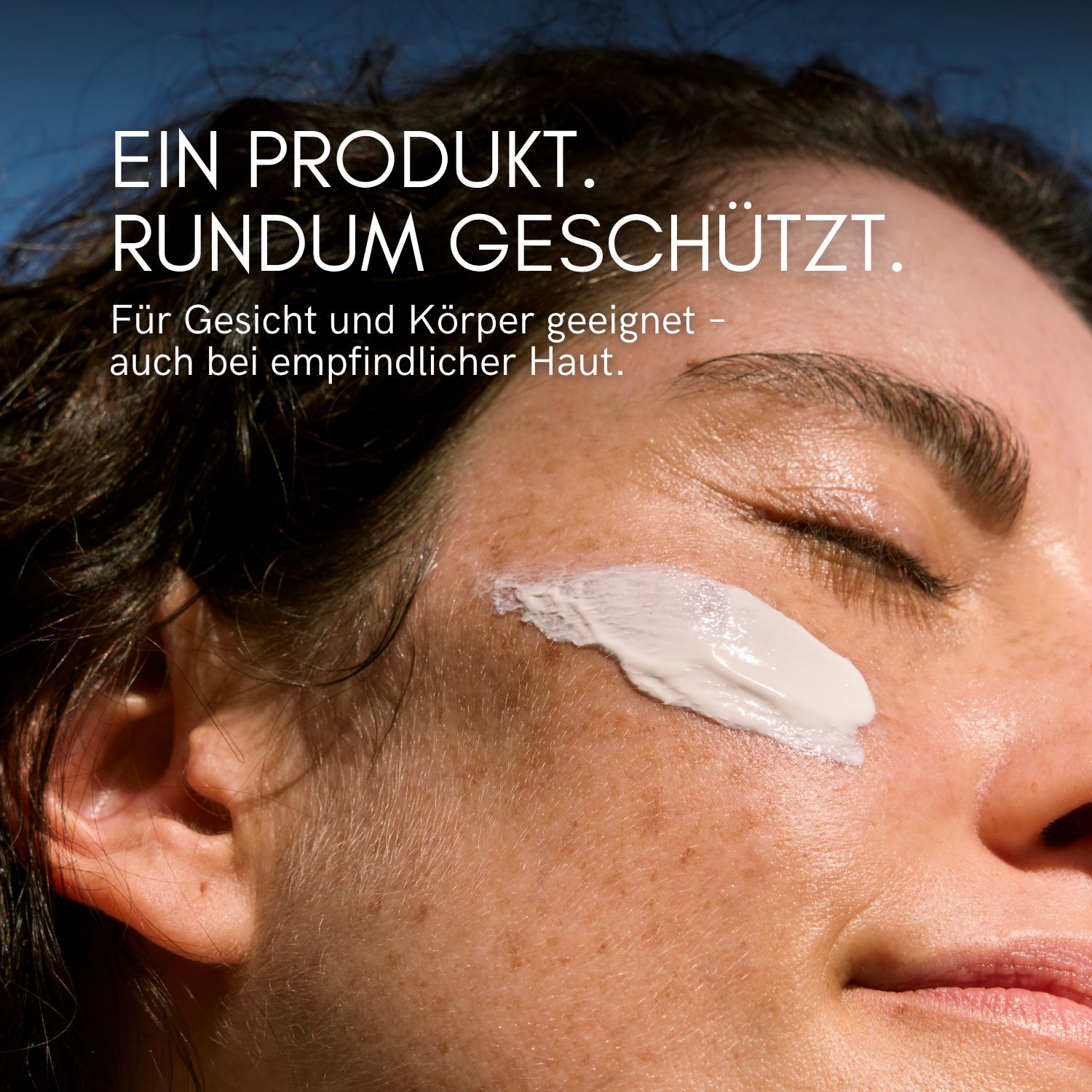 Gesicht mit aufgetragener Sonnencreme. Text: Für Gesicht und Körper geeignet, auch für empfindliche Haut.