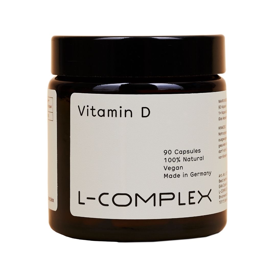 Braune Glasdose mit schwarzem Deckel. Etikett mit "Vitamin D" und "L-COMPLEX". Enthält 90 Kapseln, vegan, 100% natürlich.