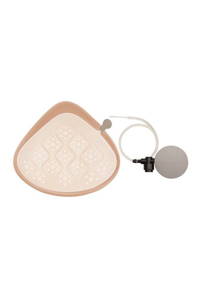 Brustprothese, beige, tropfenförmig. Innenseite mit Noppenmuster. Mit Zubehör: Kugel und Schlauch.