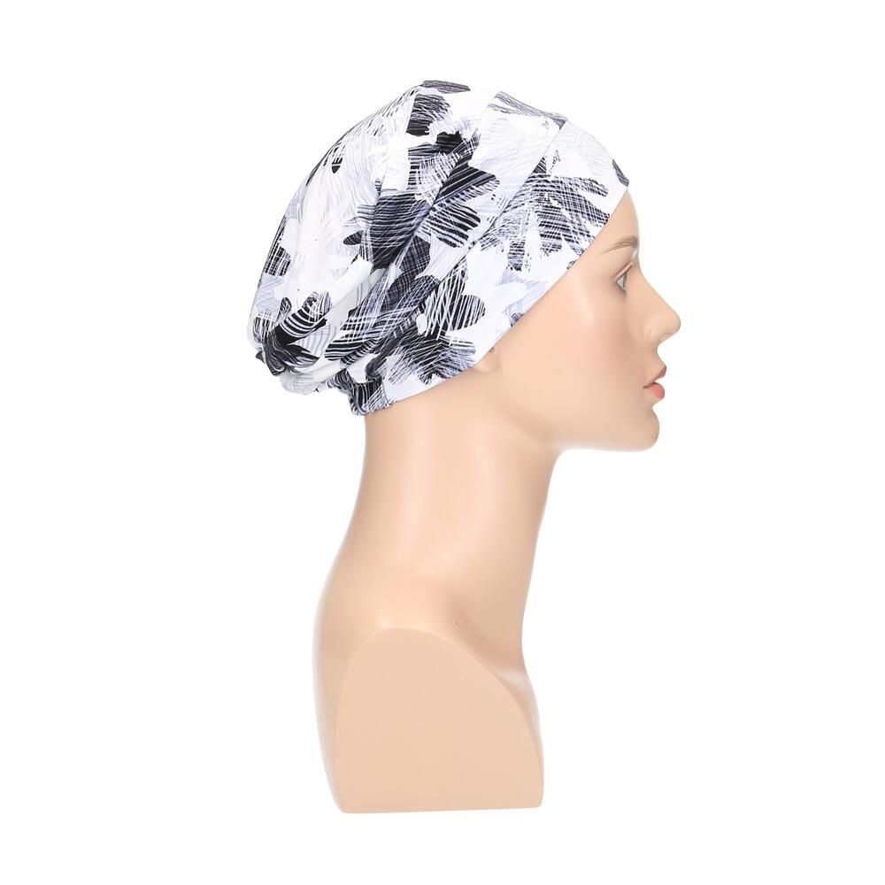 Turban mit floralem Muster in Weiß, Grau und Schwarz. Seitenansicht auf einer Büste.