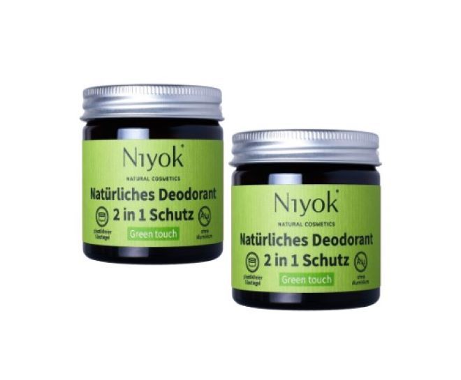 Zwei Gläser Niyok 2-in-1 Deocreme, Naturkosmetik, vegan. Die Gläser sind aus dunklem Glas mit silbernen Deckeln. Auf den Gläsern befindet sich ein grünes Etikett mit dem Markennamen Niyok, dem Produktnamen und der Aufschrift "Green touch".