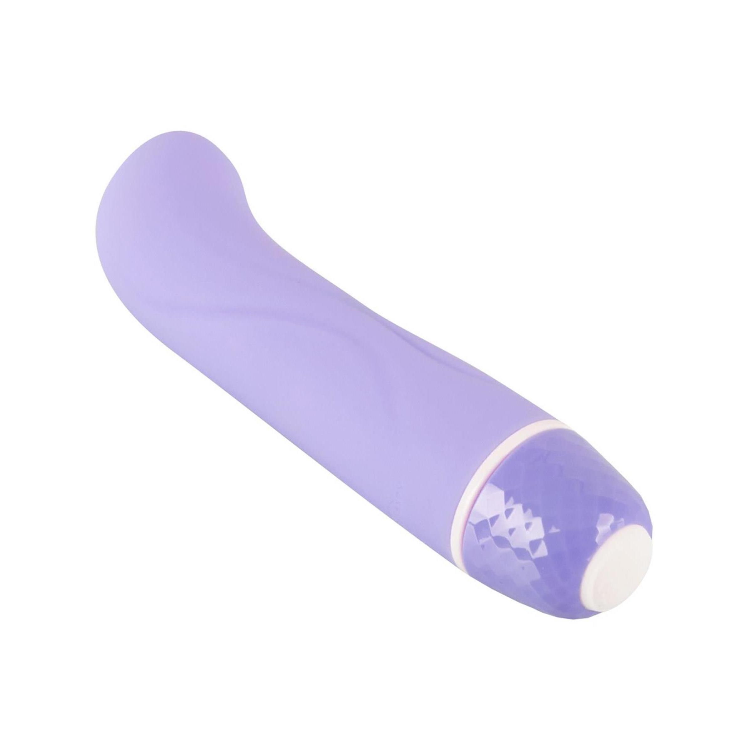 Lila Vibrator. Gebogene Form, abgerundete Spitze. Wellenförmige Oberfläche. Weißer Sockel mit facettiertem Muster.