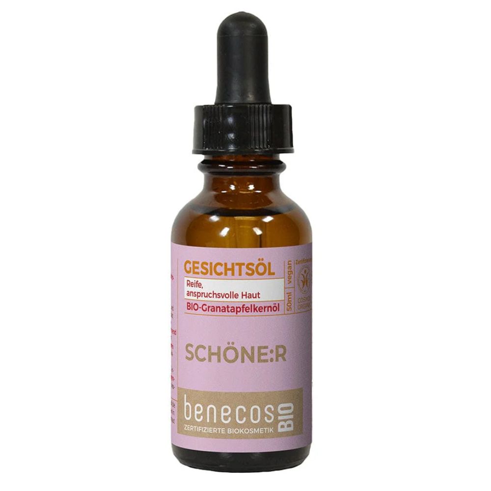 Braune Glasflasche mit Pipettenverschluss, gefüllt mit goldenem Gesichtsöl. Rosa Etikett mit Produktinformationen.