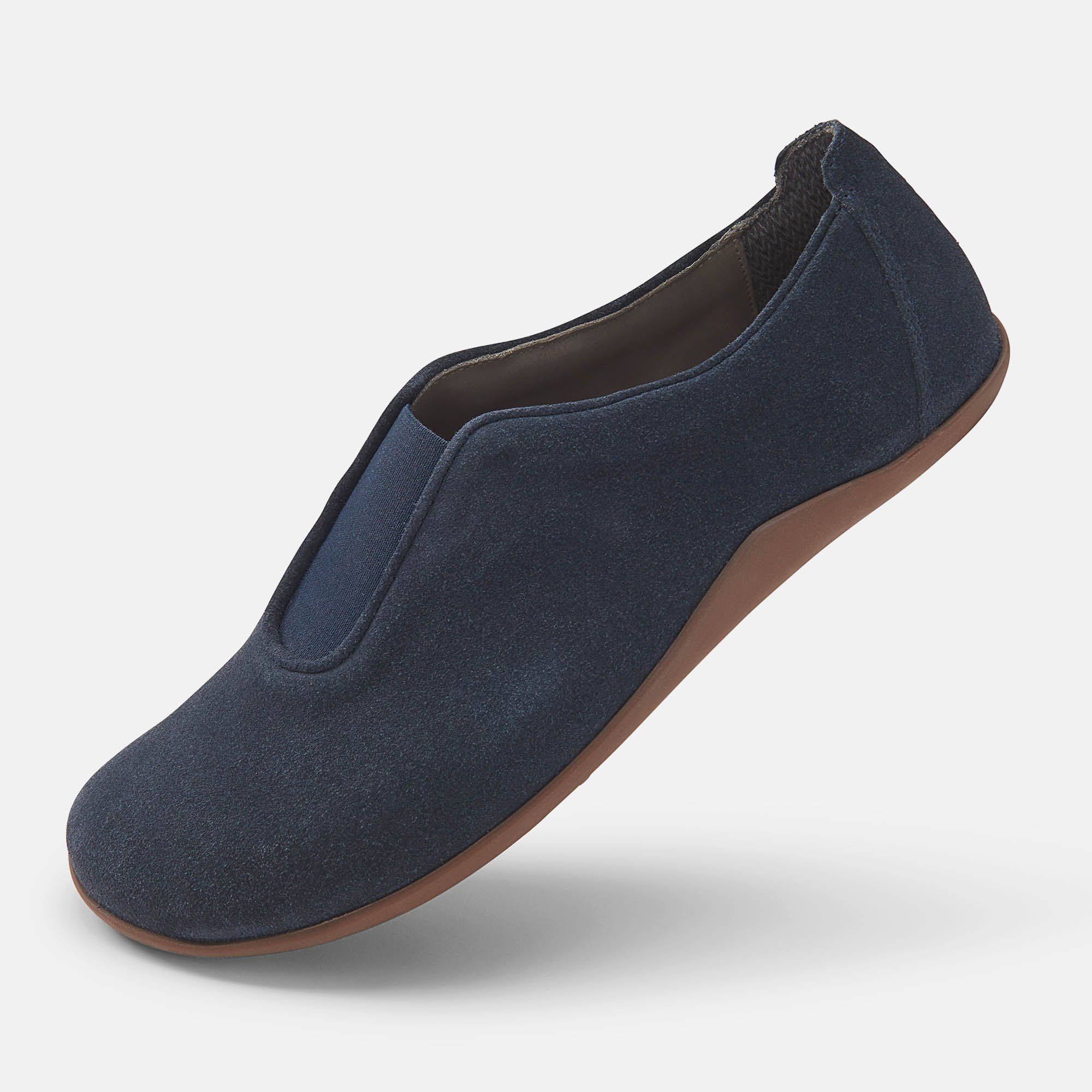 Blauer Slipper mit brauner Sohle. Die Schuhe sind leicht schräg gestellt.